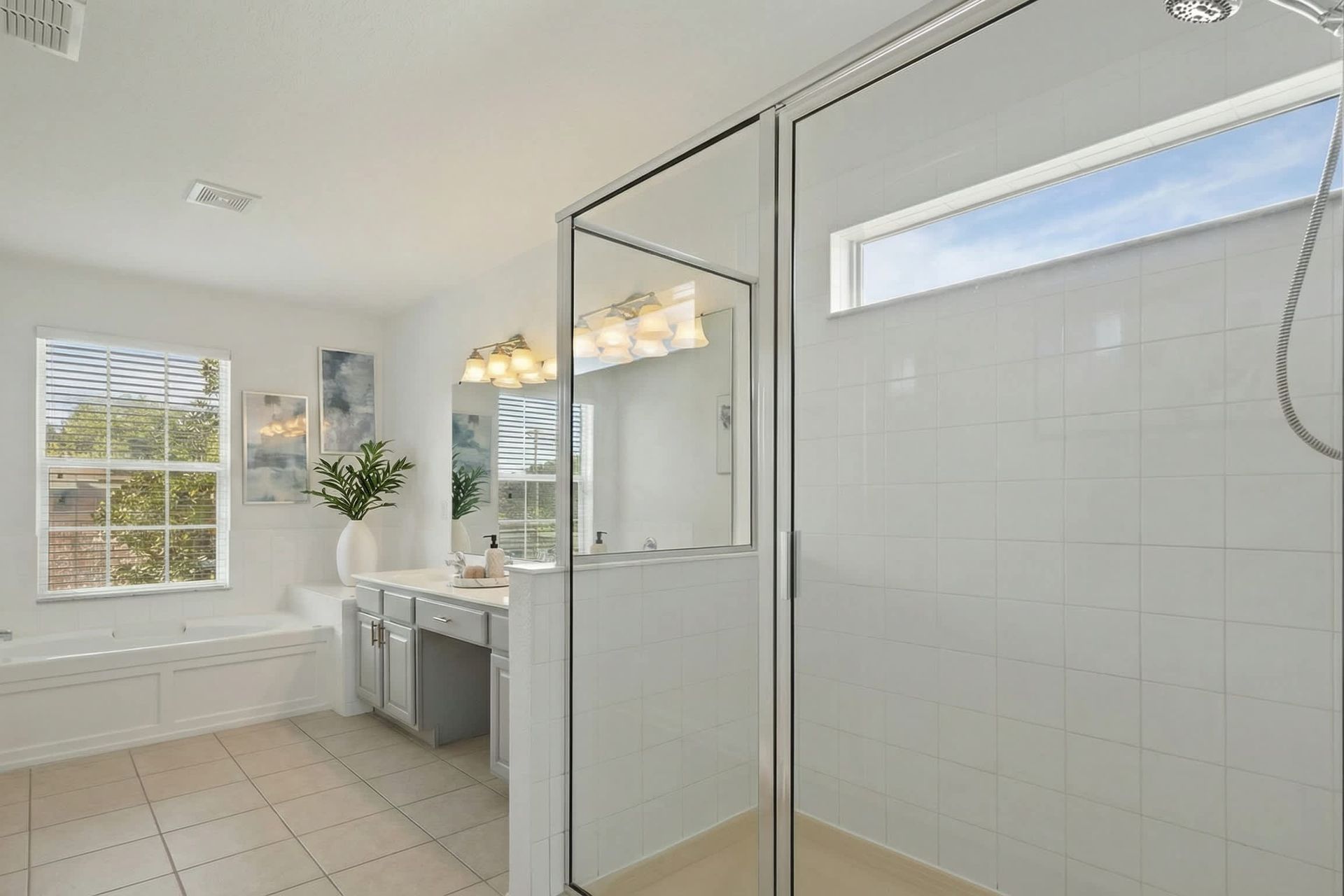 Bright, airy bathroom featuring spacious shower, soaking tub, and modern vanity.