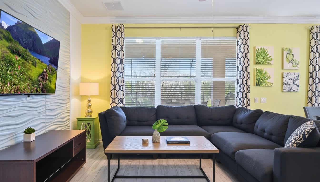Cozy family room with plush sectional, large TV, and views of the pool area.