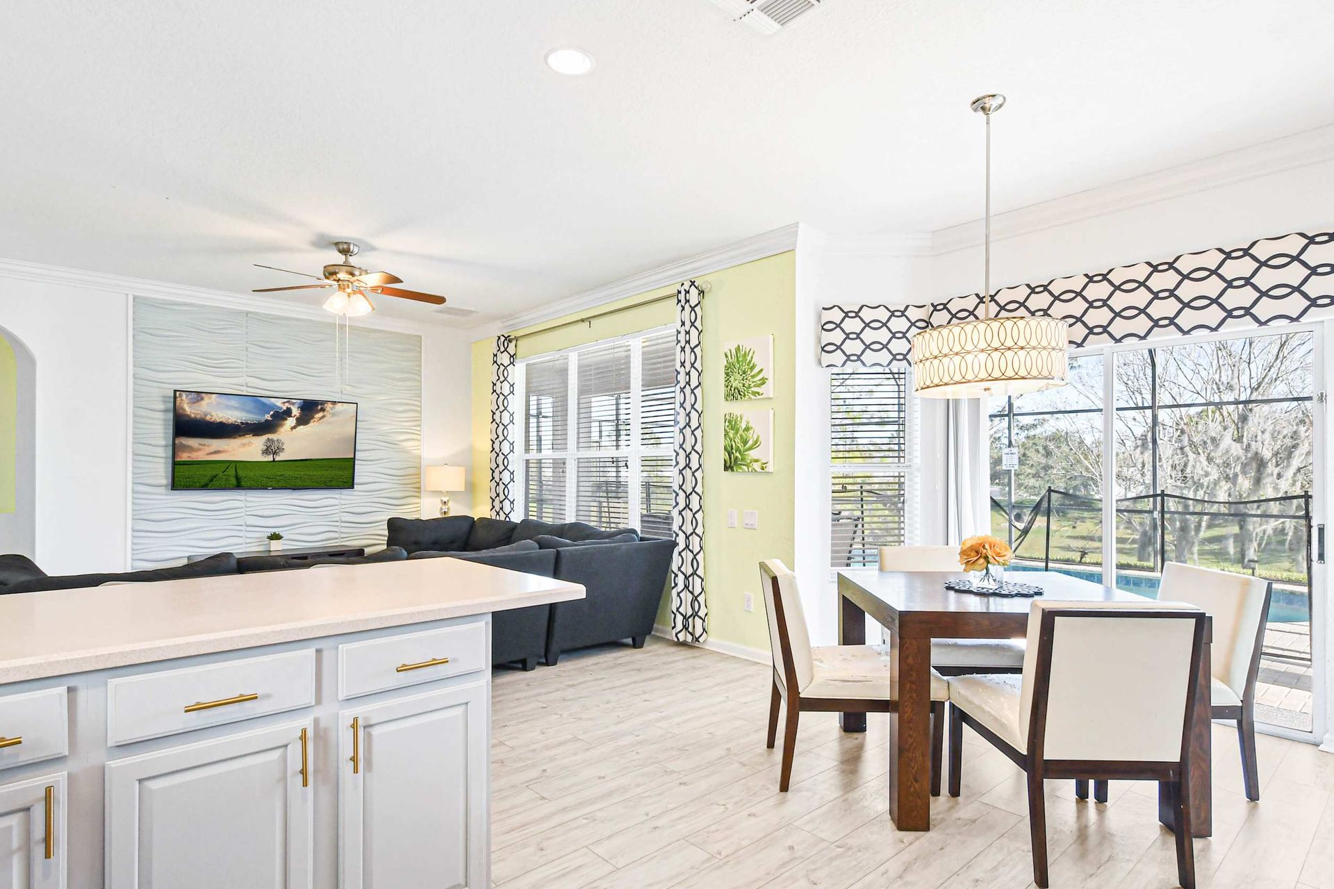 Bright open kitchen and living area with pool views and cozy seating.