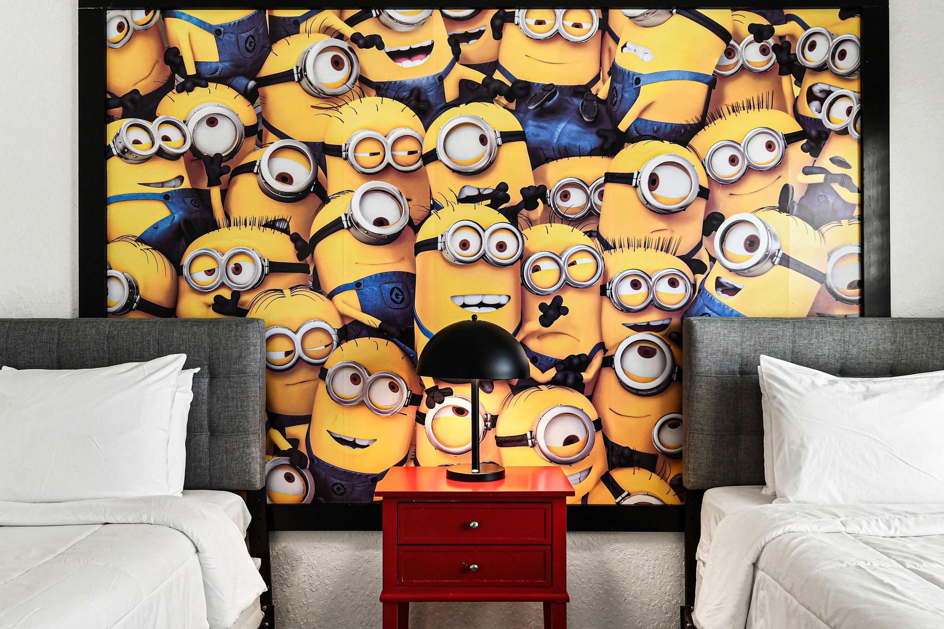 Playful Minions twin room with bold wall art, perfect for kids and fun stays.