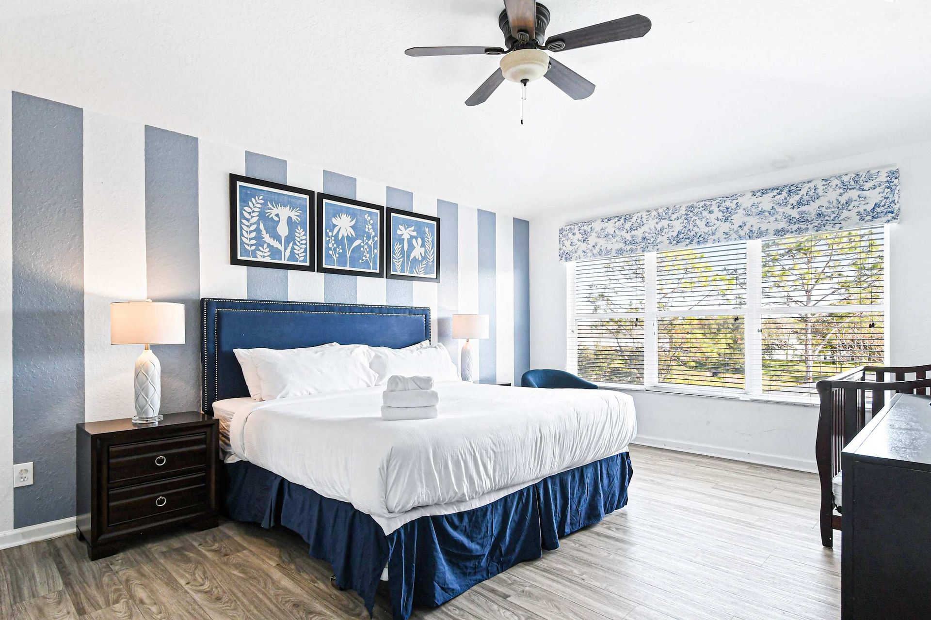 Spacious master suite with king bed, crib, natural light, and calming decor.