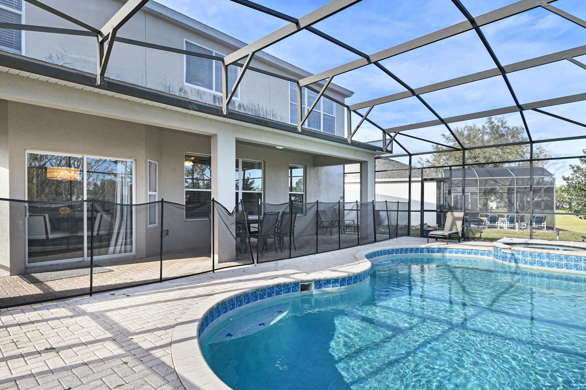 Spacious screened pool with spa and plenty of seating for outdoor relaxation.