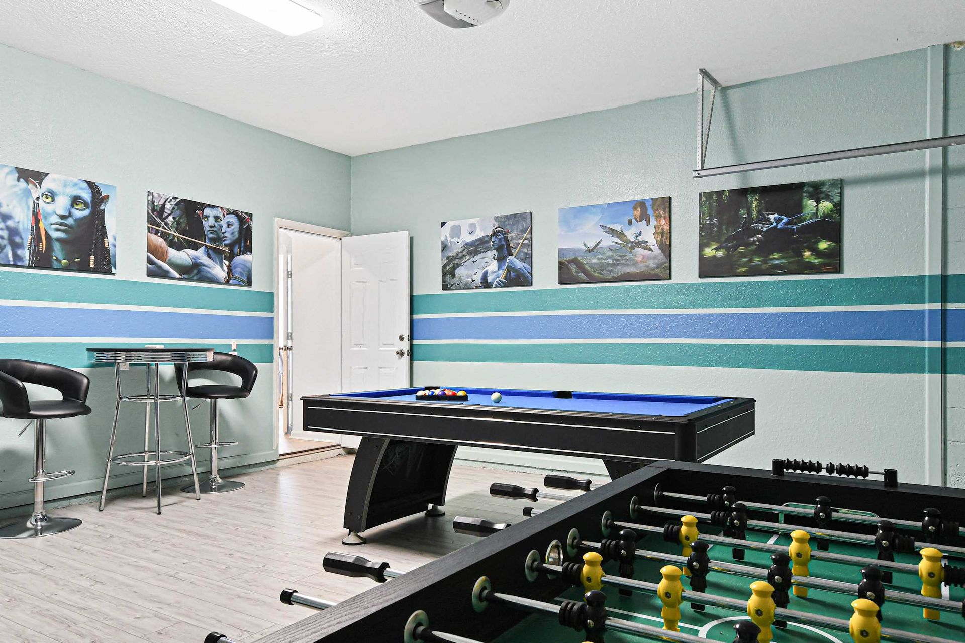 Game room fun with pool, foosball, and bar seating in a vibrant themed space.