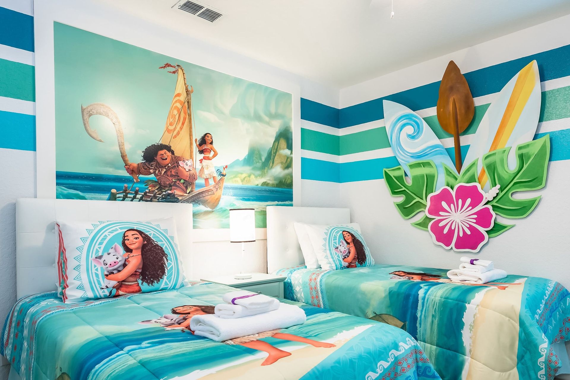 Enchanting Moana-themed room with twin beds, vibrant decor, perfect for kids.