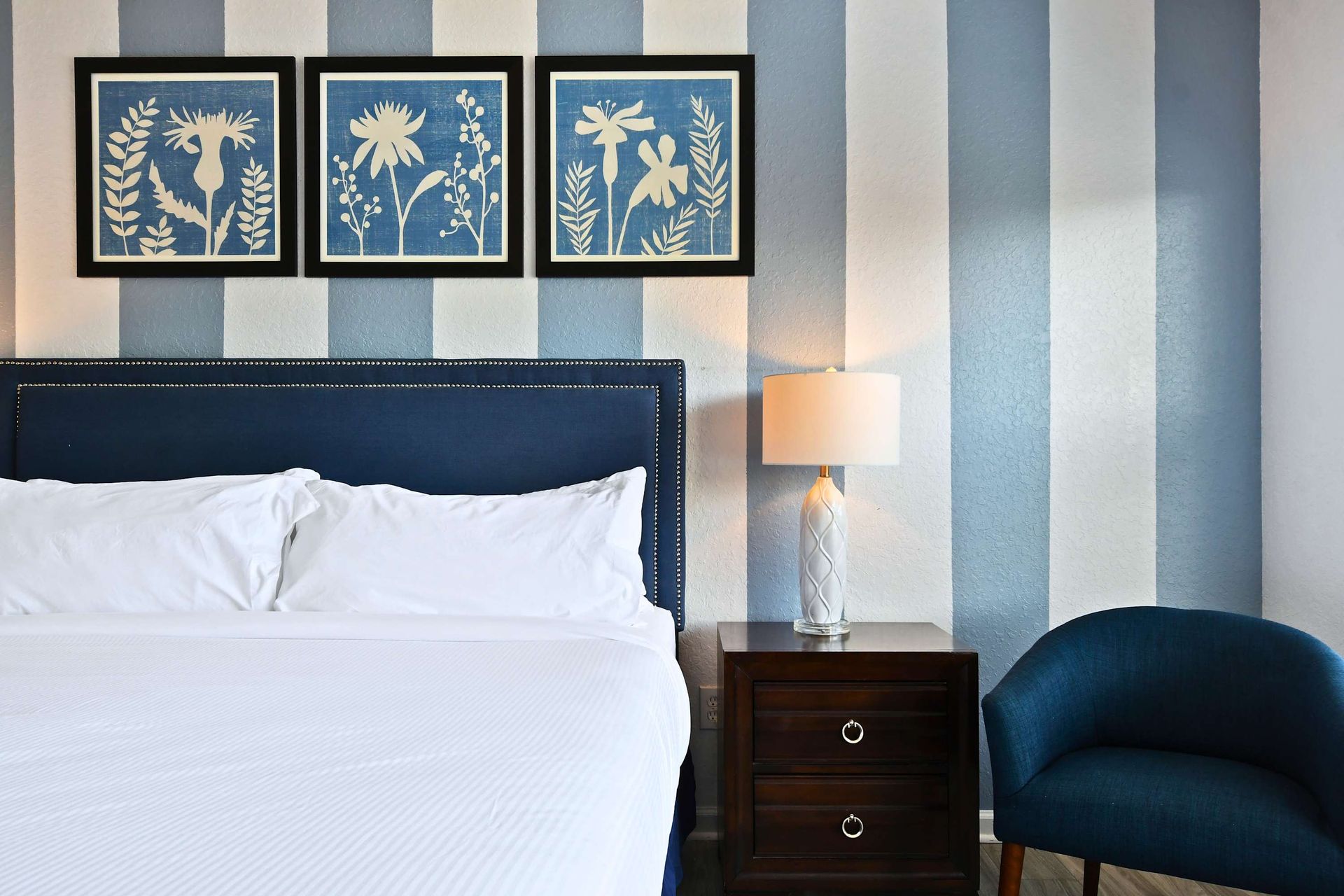 Elegant king suite with bold stripes, cozy seating, and stylish modern touches.