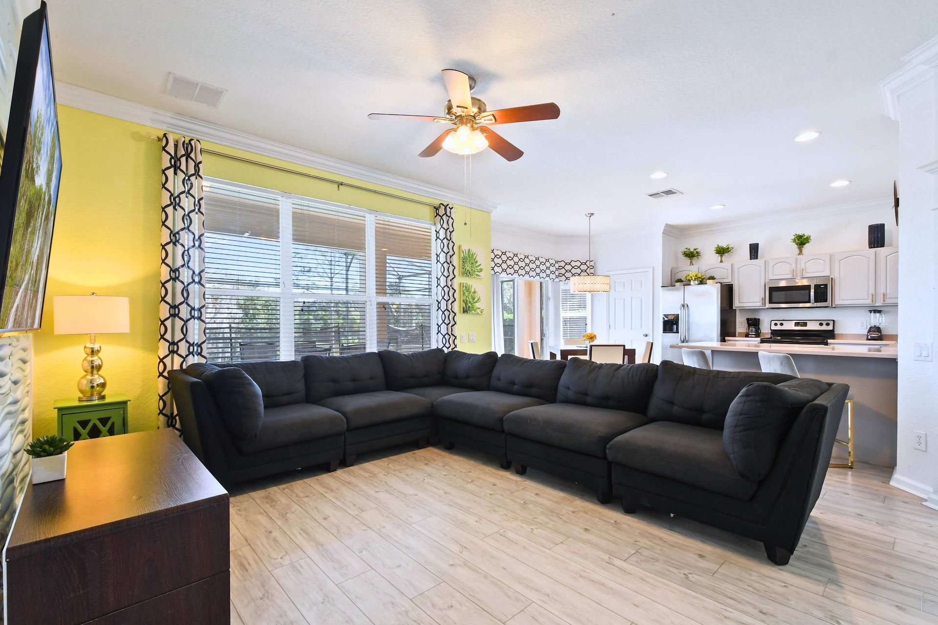 Spacious open family room with comfy sectional, large TV, and kitchen views.