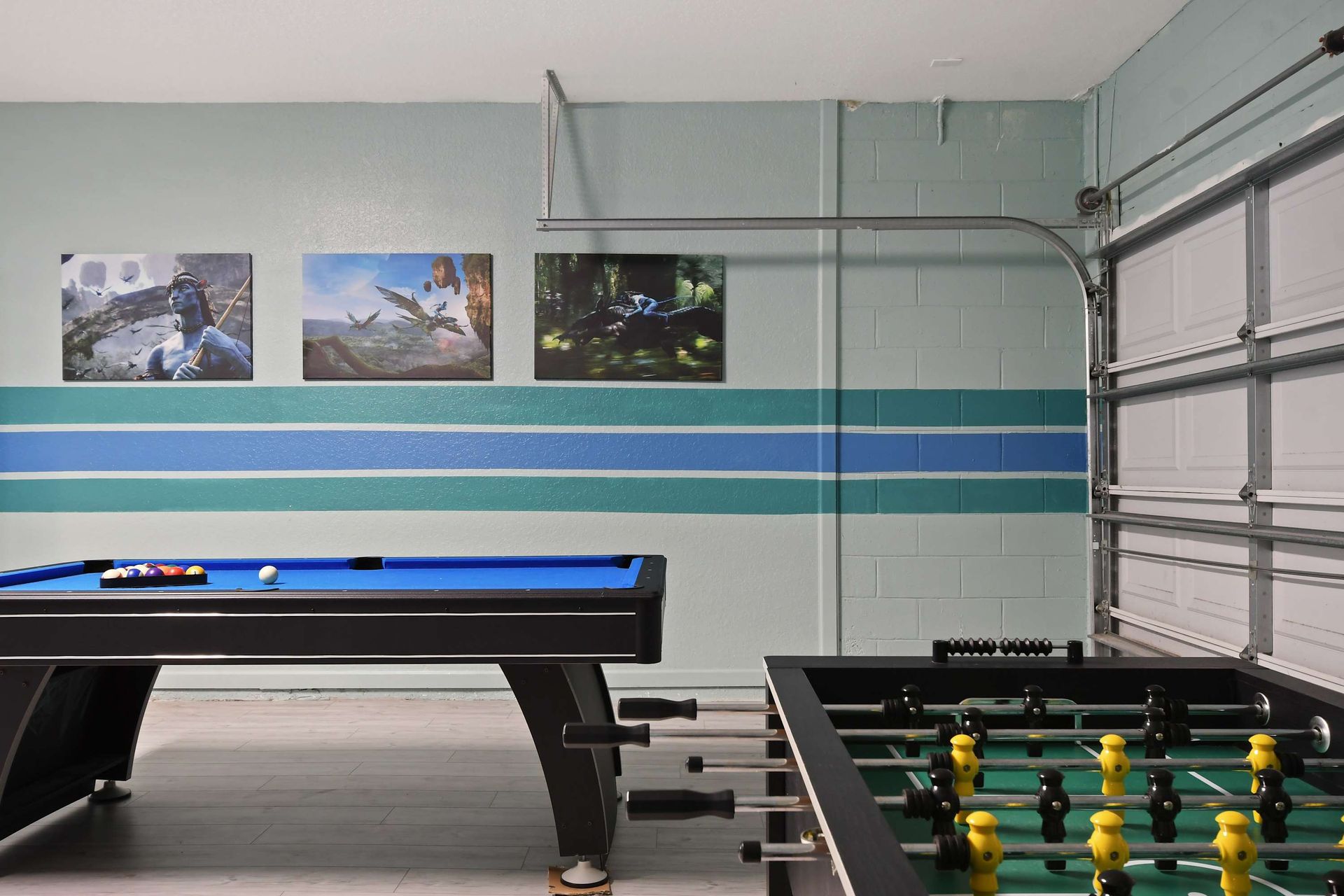 Enjoy friendly competition in this stylish game room with pool and foosball tables.