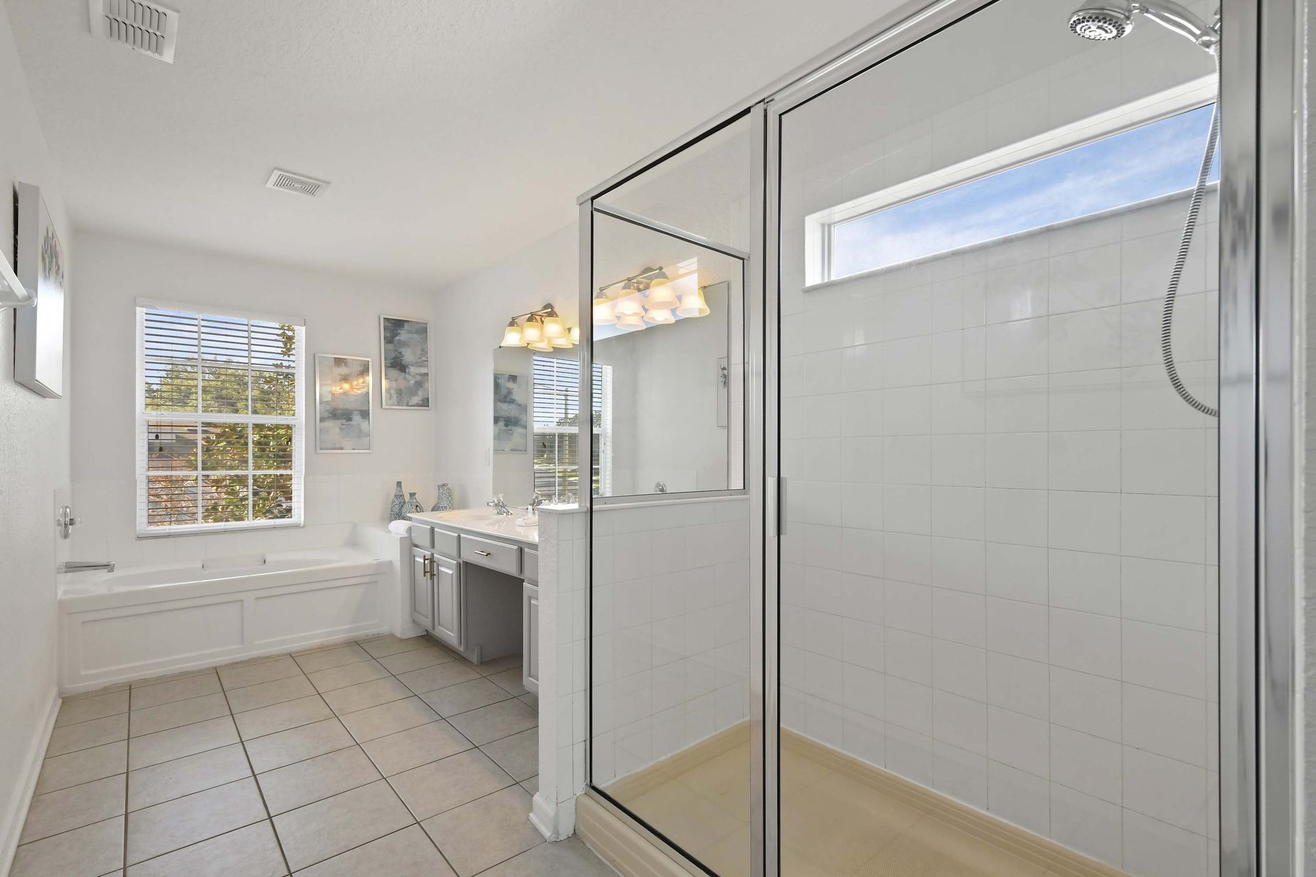 Bright, airy bathroom featuring spacious shower, soaking tub, and modern vanity.