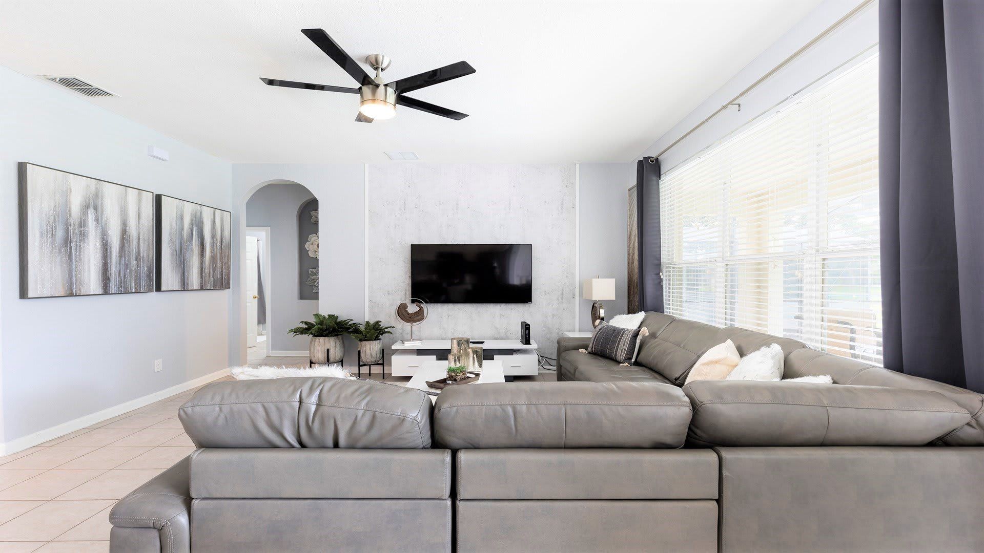 Stylish living room with a cozy sectional, smart TV, and plenty of natural light!