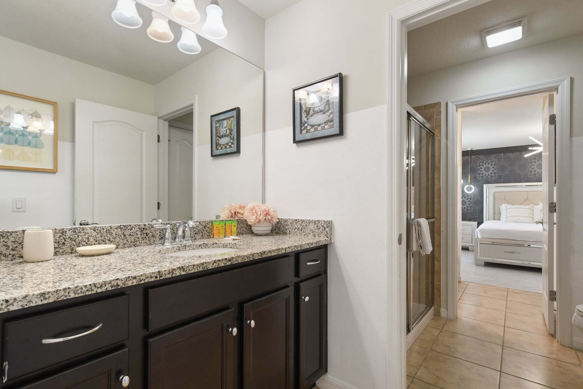Elegant bathroom with granite vanity, walk-in shower, and art decor.