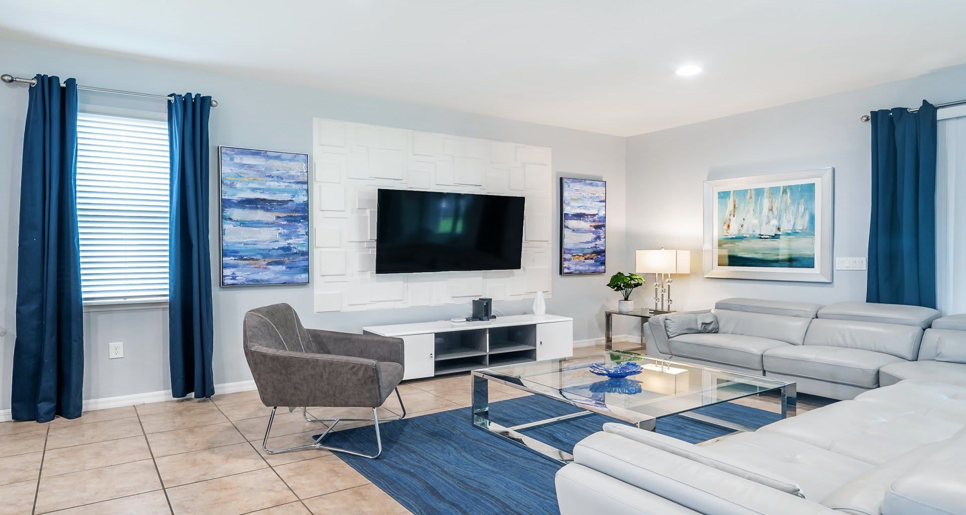Stylish living room with modern decor, large TV, and comfy leather seating.