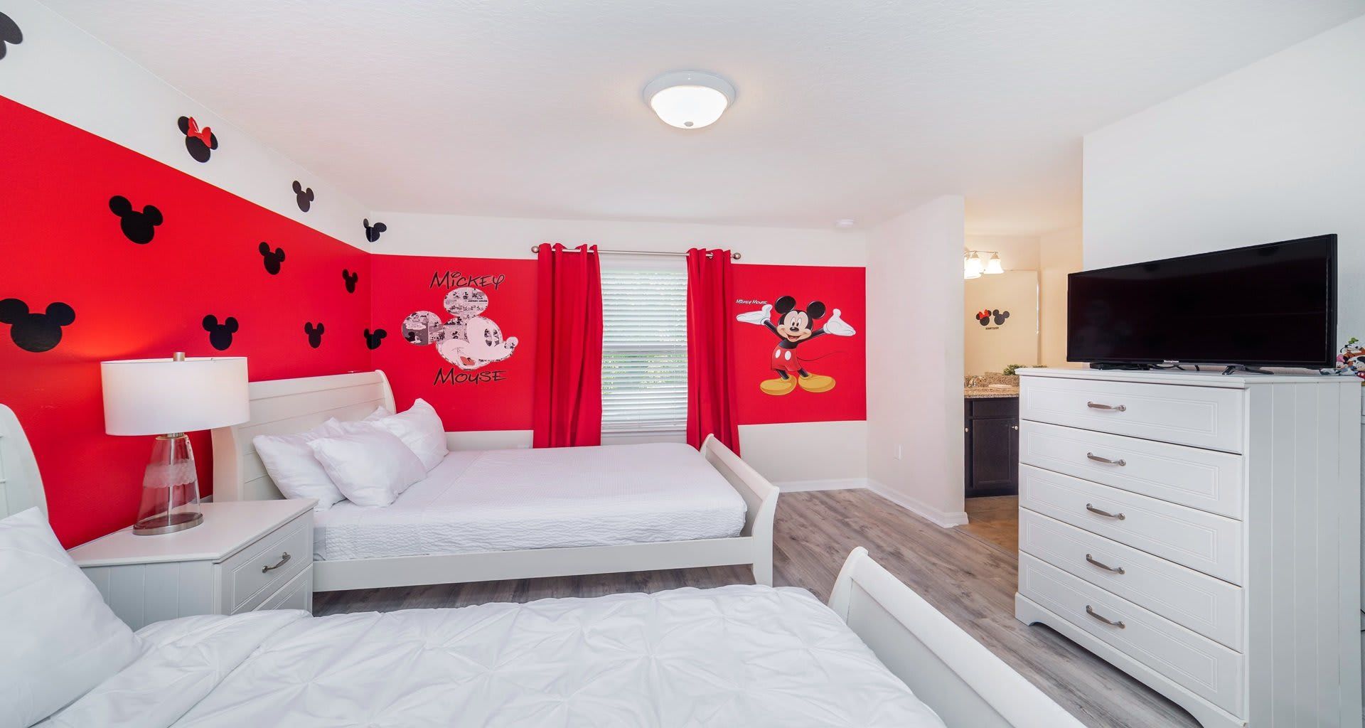Cheerful Mickey-themed room with twin beds, ideal for young Disney fans.