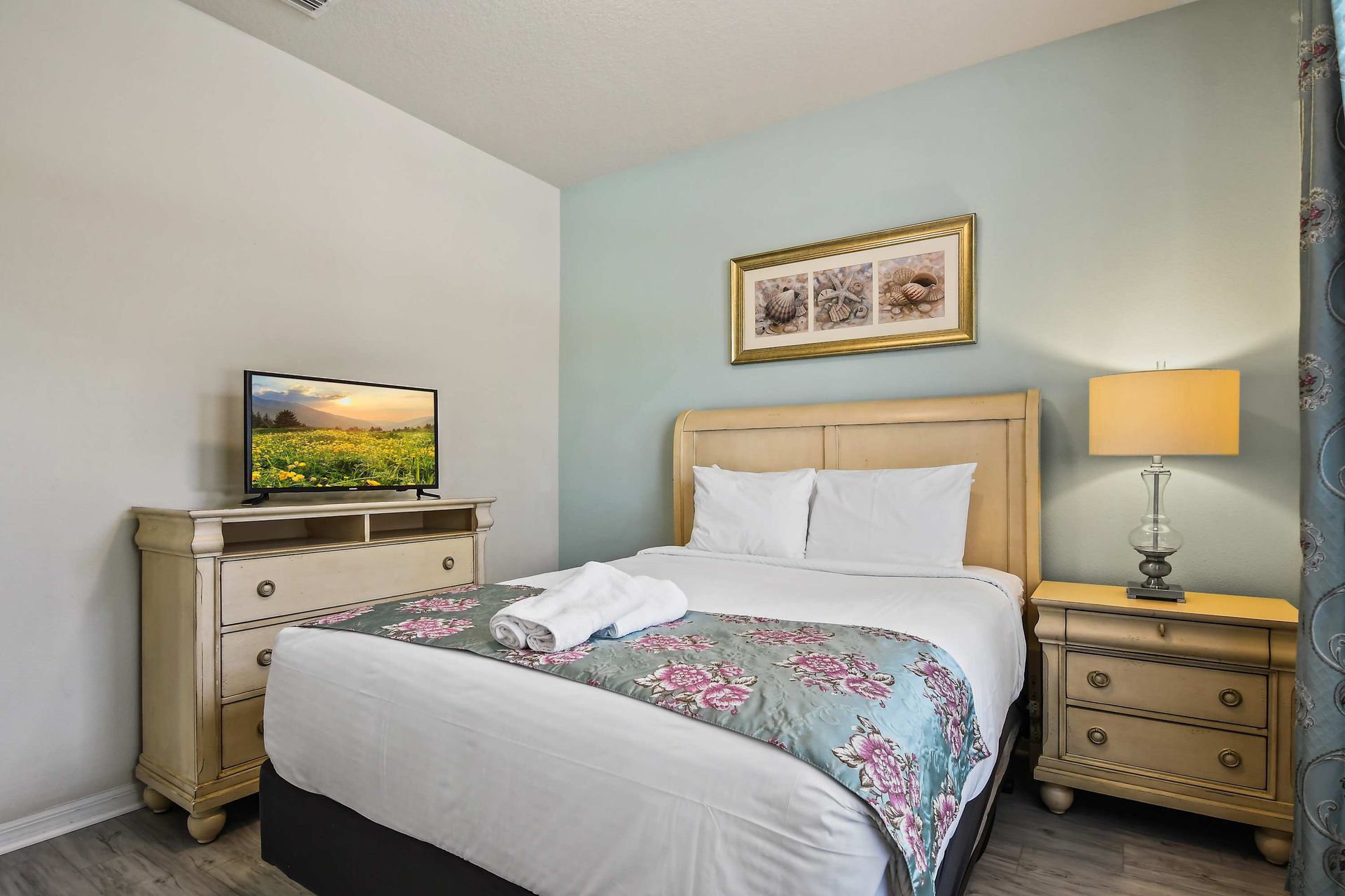 Cozy bedroom with floral accents, soft lighting, and serene garden views.