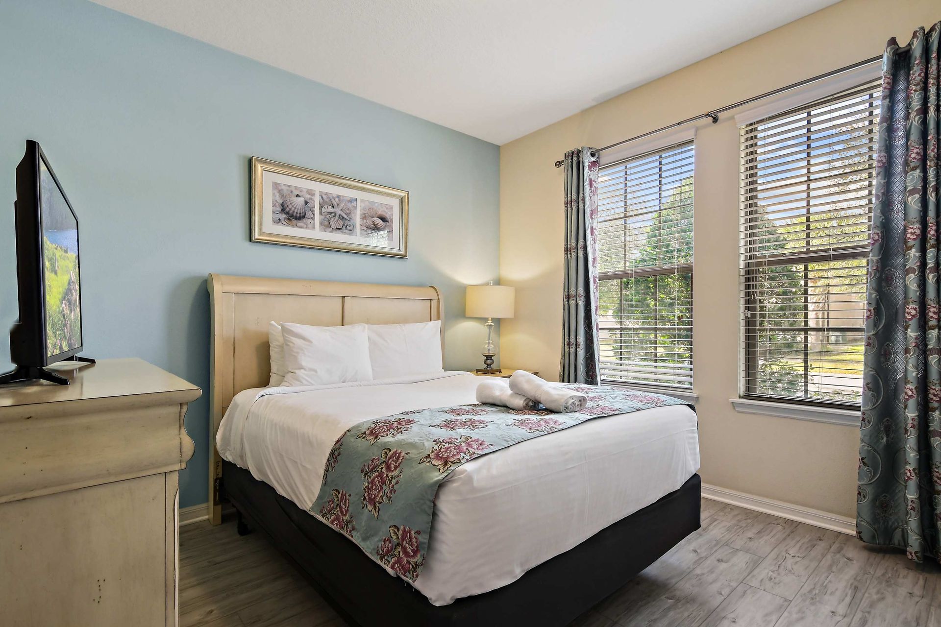 Cozy bedroom with floral accents, soft lighting, and serene garden views.