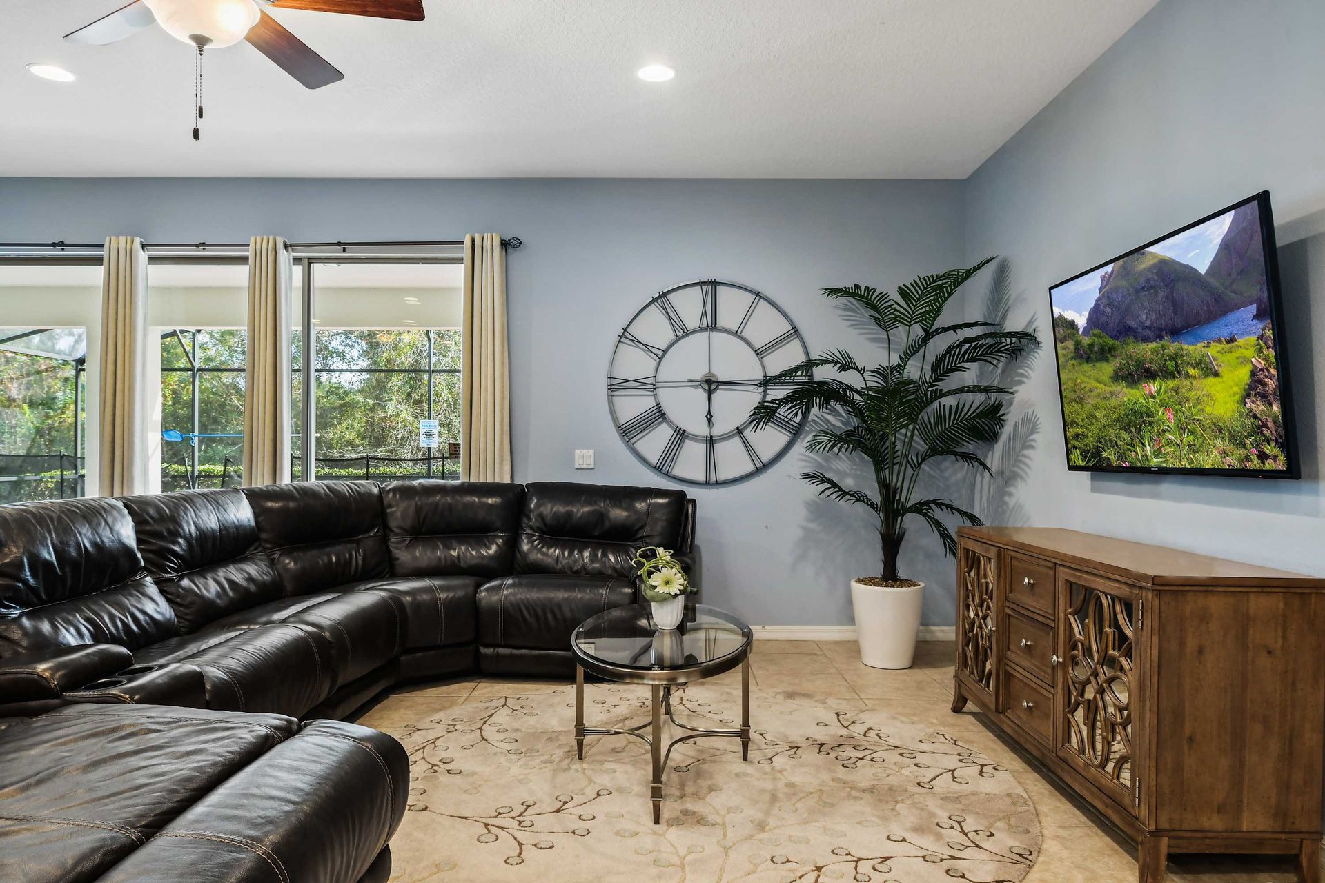 Spacious living area with recliners, pool view, and large TV for cozy evenings.