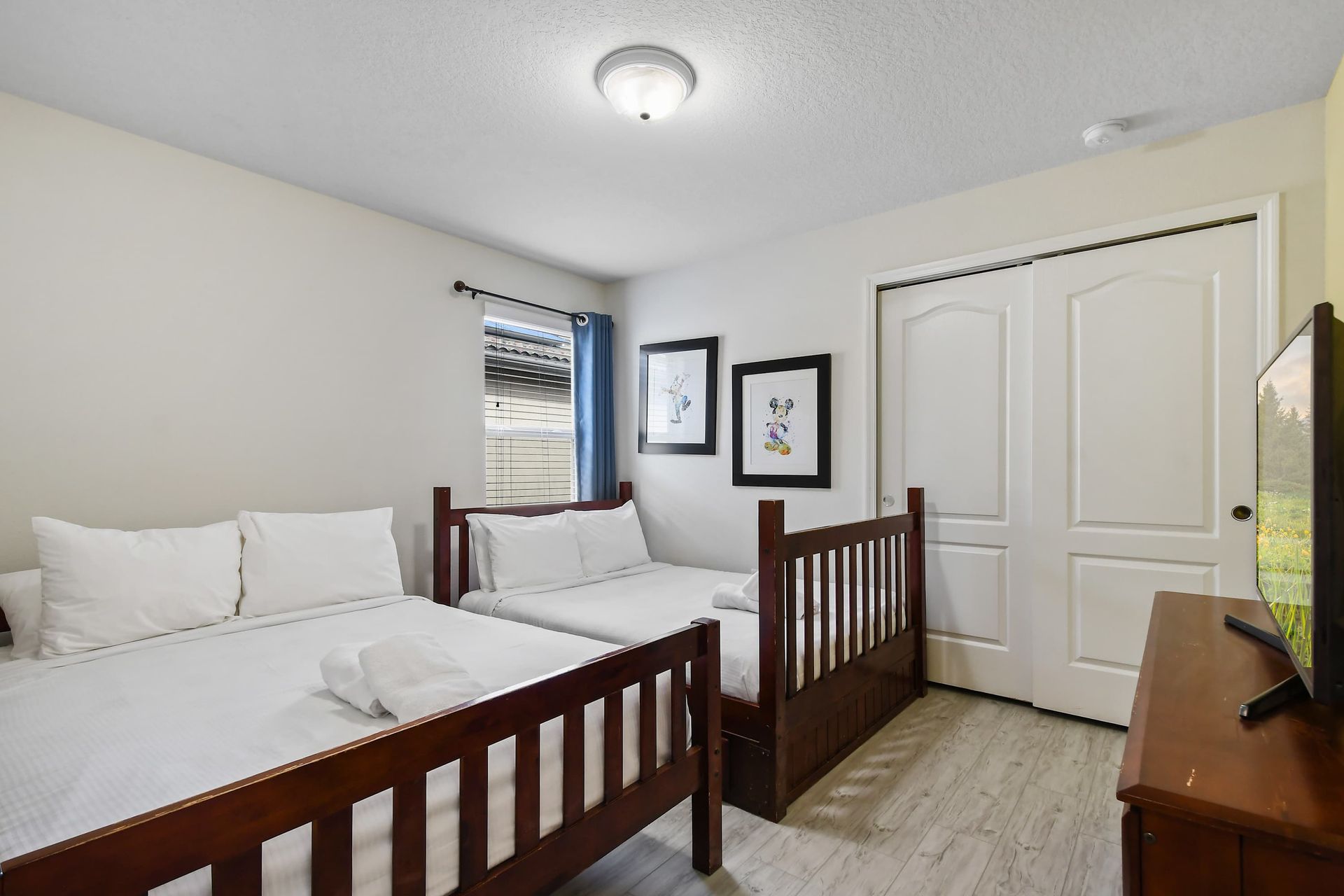 Cozy bedroom with twin beds, playful art, and a TV for unwinding.