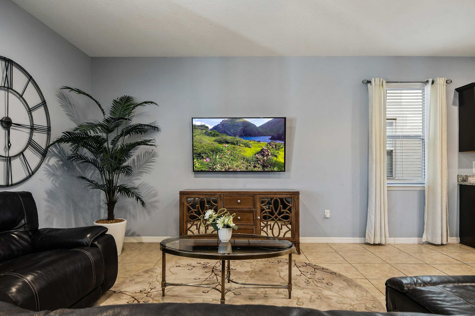 Spacious living area with recliners, pool view, and large TV for cozy evenings.