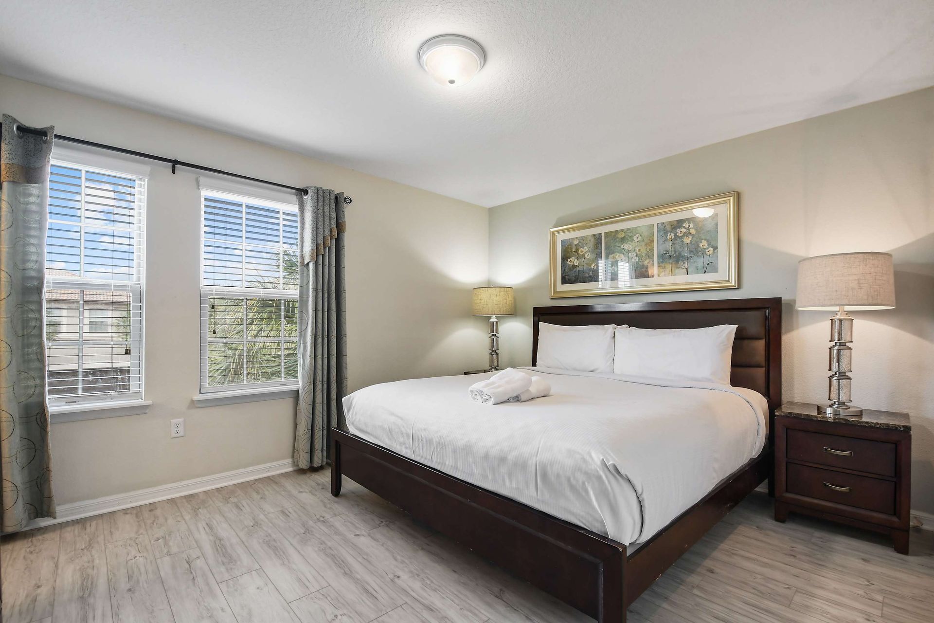 Bright bedroom with a plush king bed, elegant decor, and natural light.