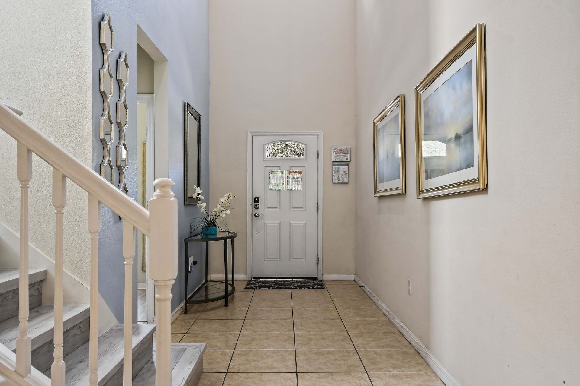 Welcoming entryway with high ceilings, tiled flooring, and soft neutral tones.