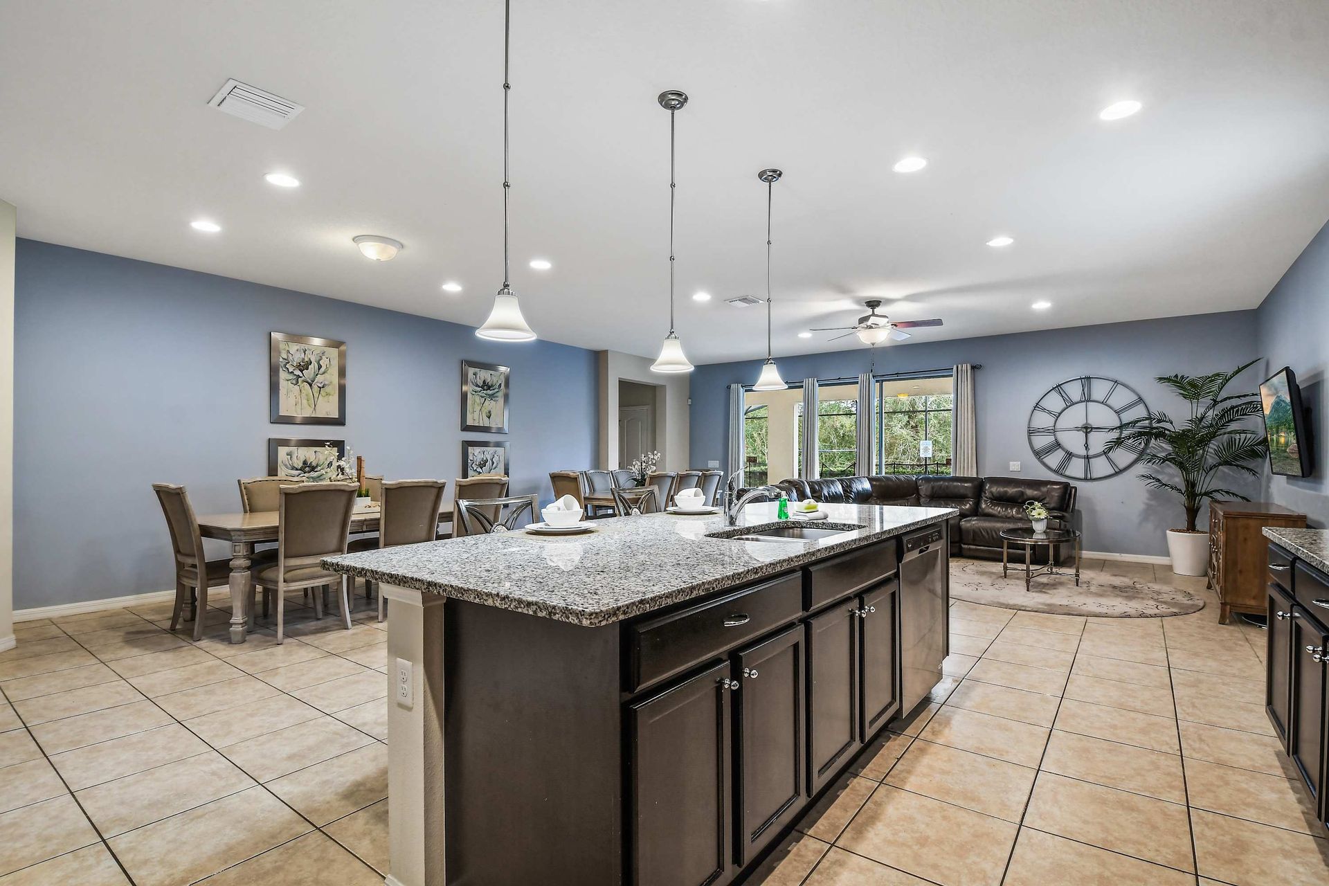 Modern open kitchen with granite island, spacious dining, and cozy living area.