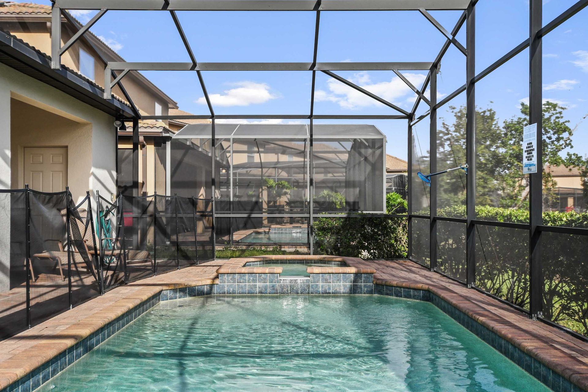 Spacious screened-in pool area with lounge seating and outdoor dining space.