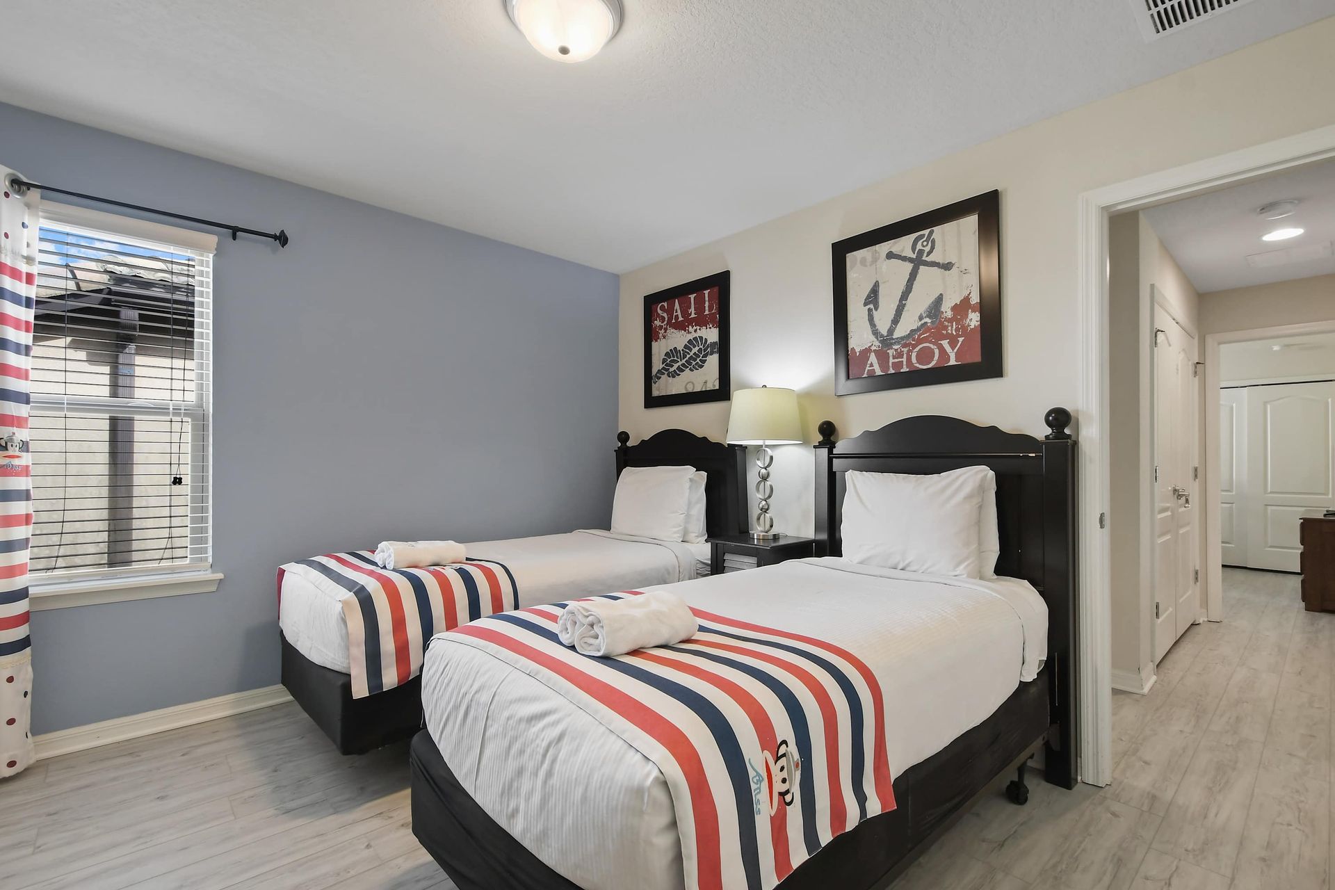 Nautical-themed bedroom with twin beds, cozy decor, and soft lighting.