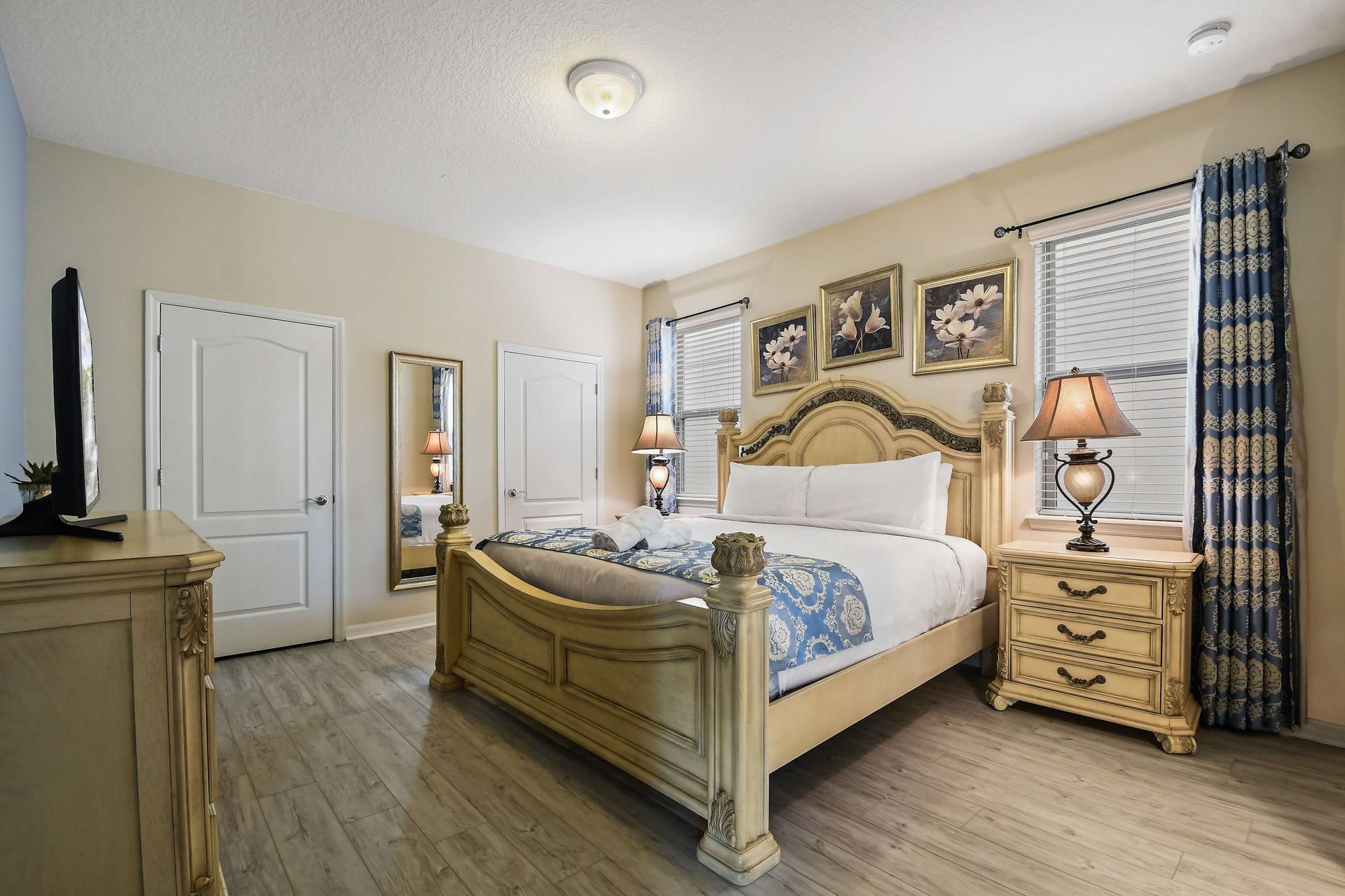 Elegant bedroom with a regal bed, ornate decor, and warm lighting.