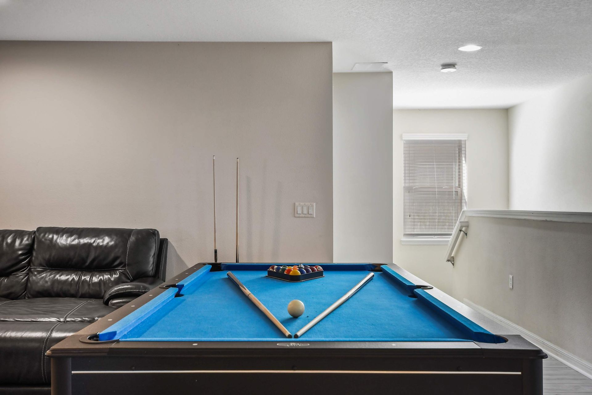 Bright game area with pool table, cozy desk nook, and elegant decor.