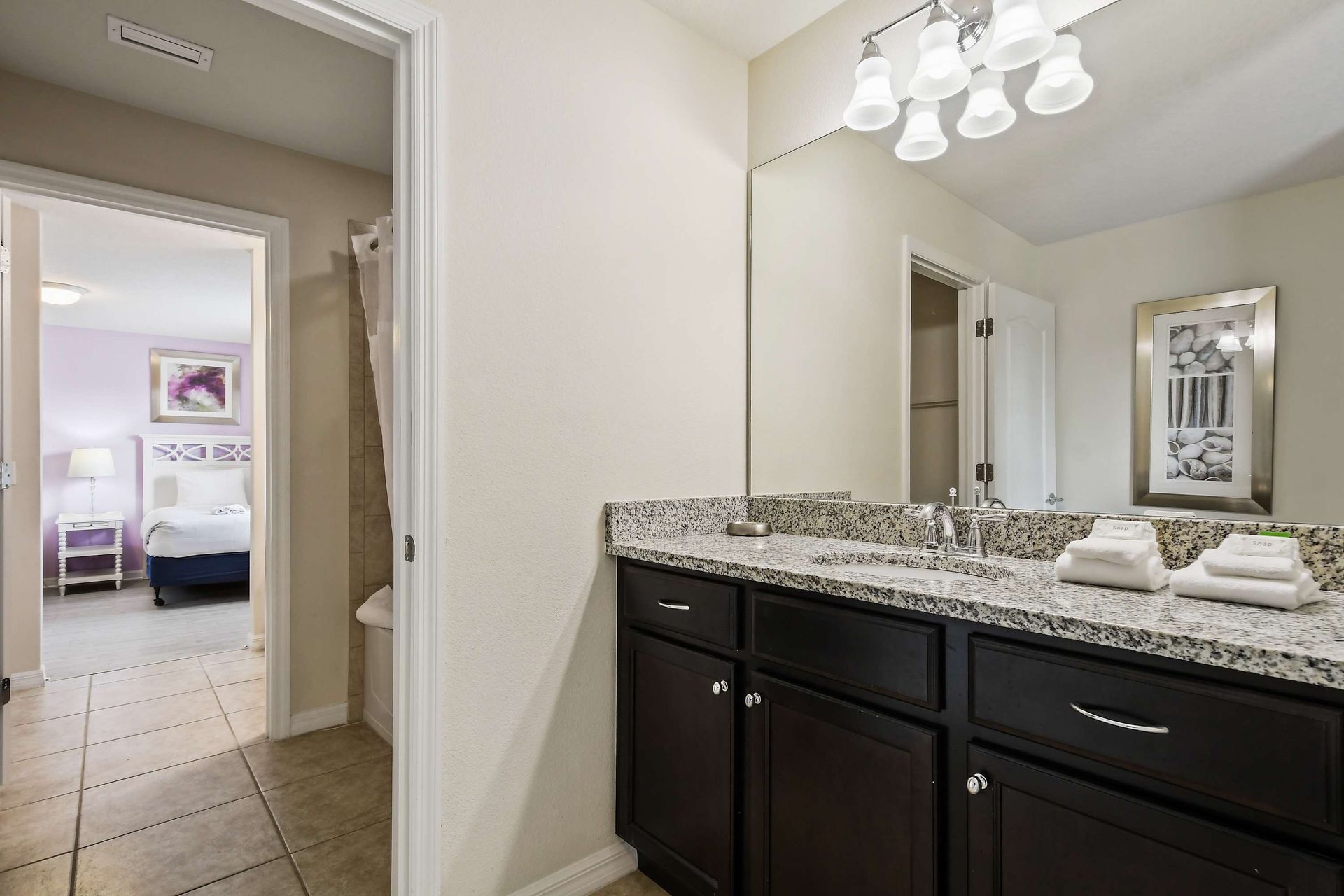 Spacious bathroom with granite countertop, dual sinks, and modern lighting.