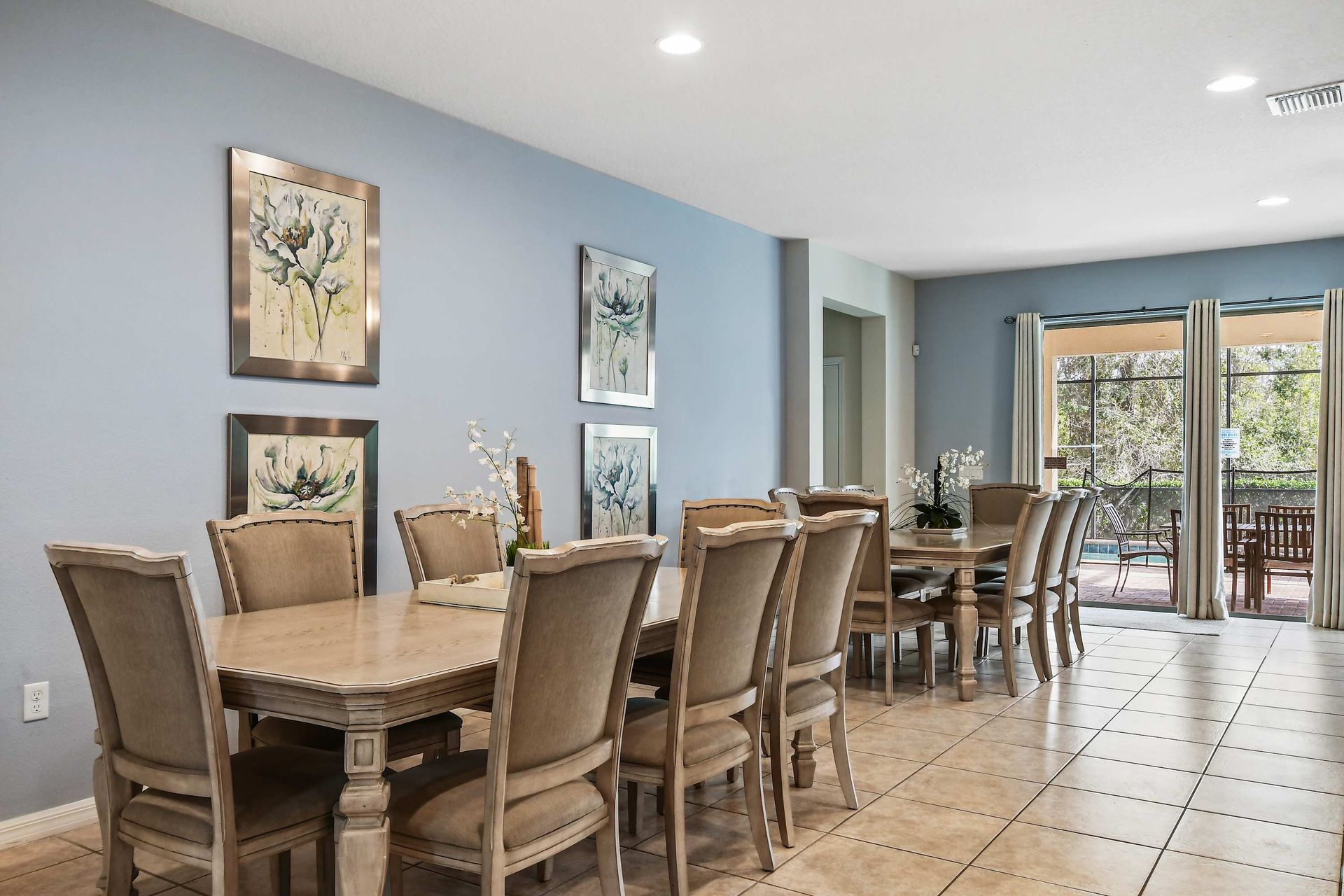Spacious dining room with elegant seating for ten, soft lighting, and decor.