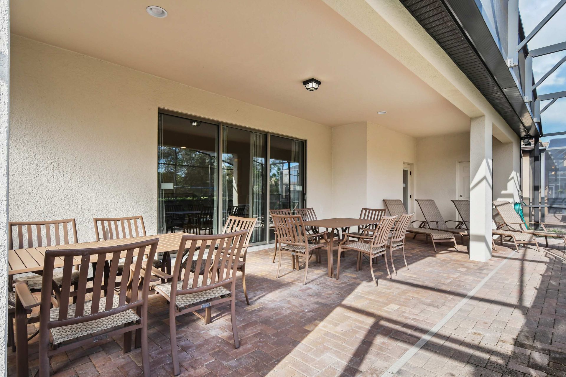 Spacious covered patio with pool views, ample seating, and relaxing ambiance.