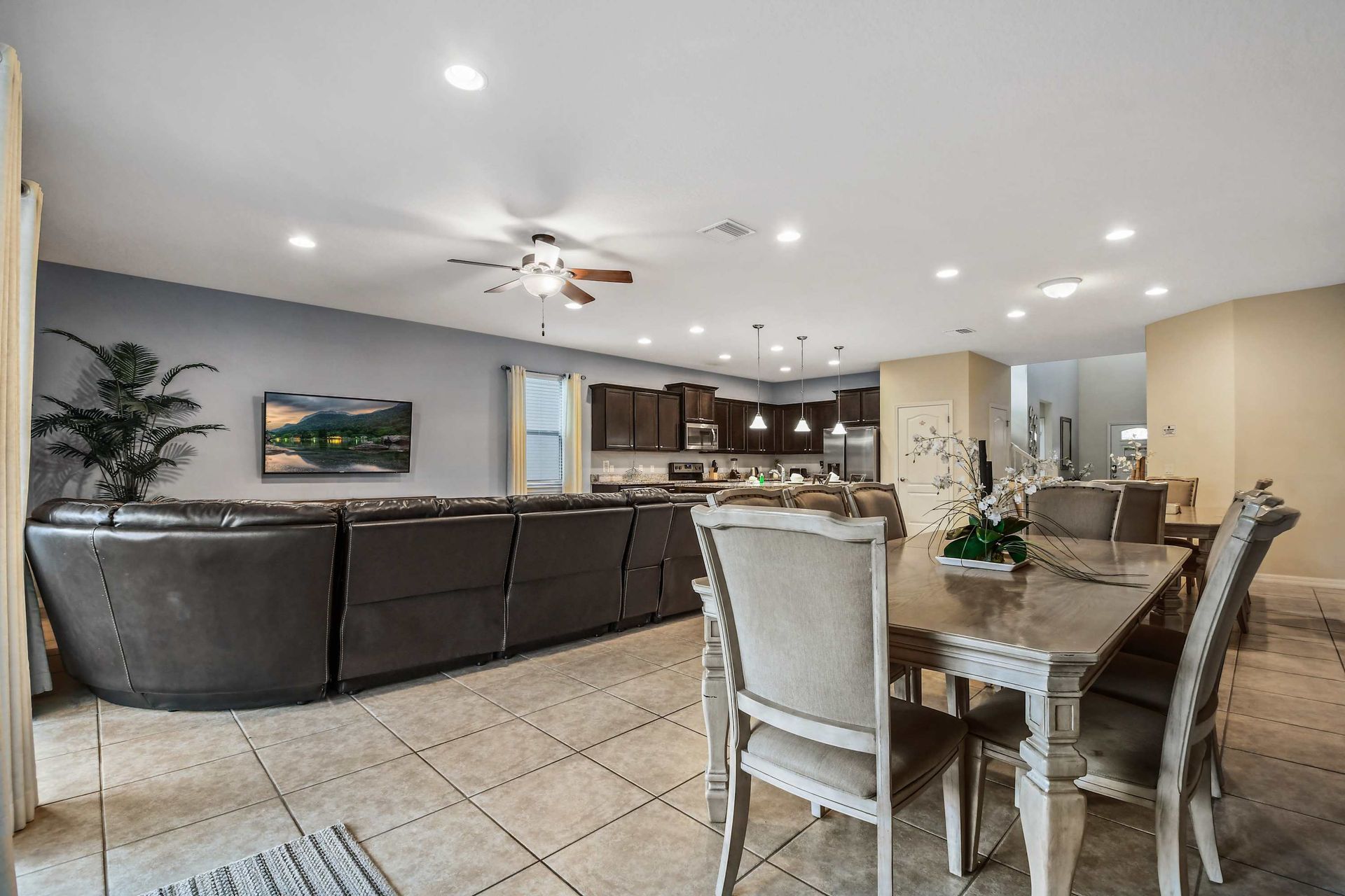 Open-plan living with a sectional sofa, modern kitchen, and elegant dining area.