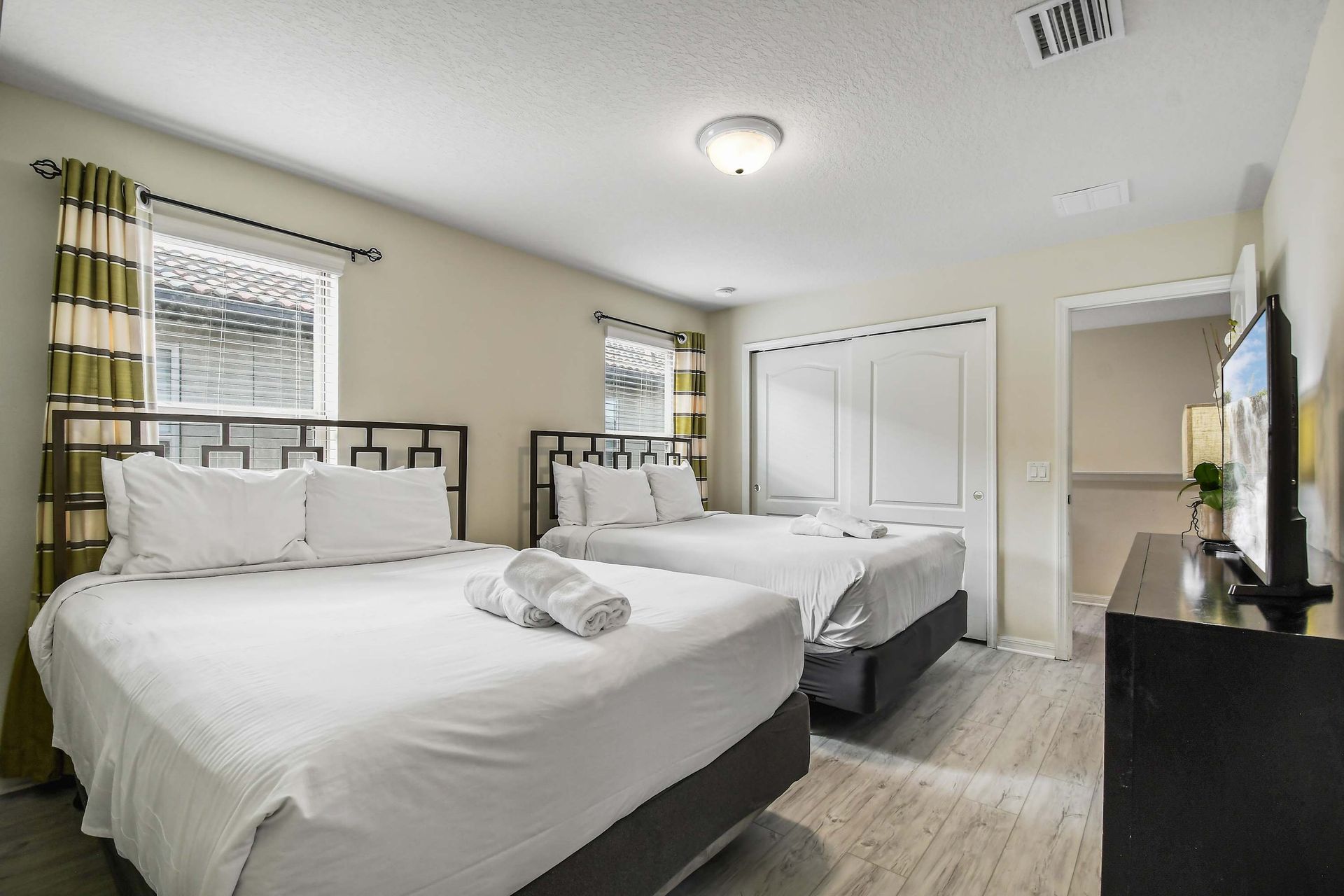 Cozy bedroom with two plush beds, ample storage, and a TV for unwinding.