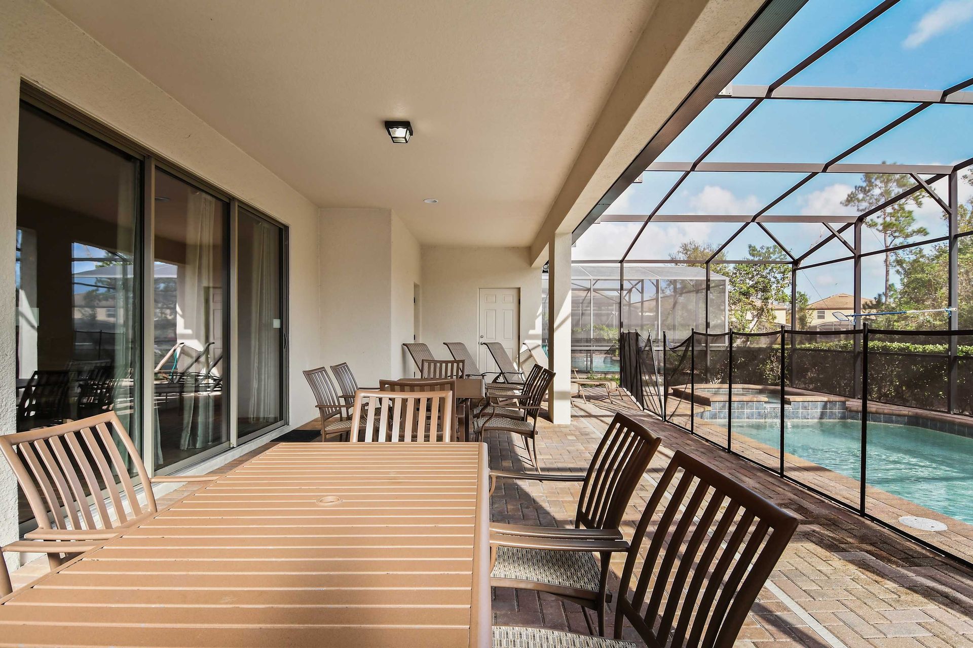 Covered patio with ample seating, pool views, and space for outdoor dining.