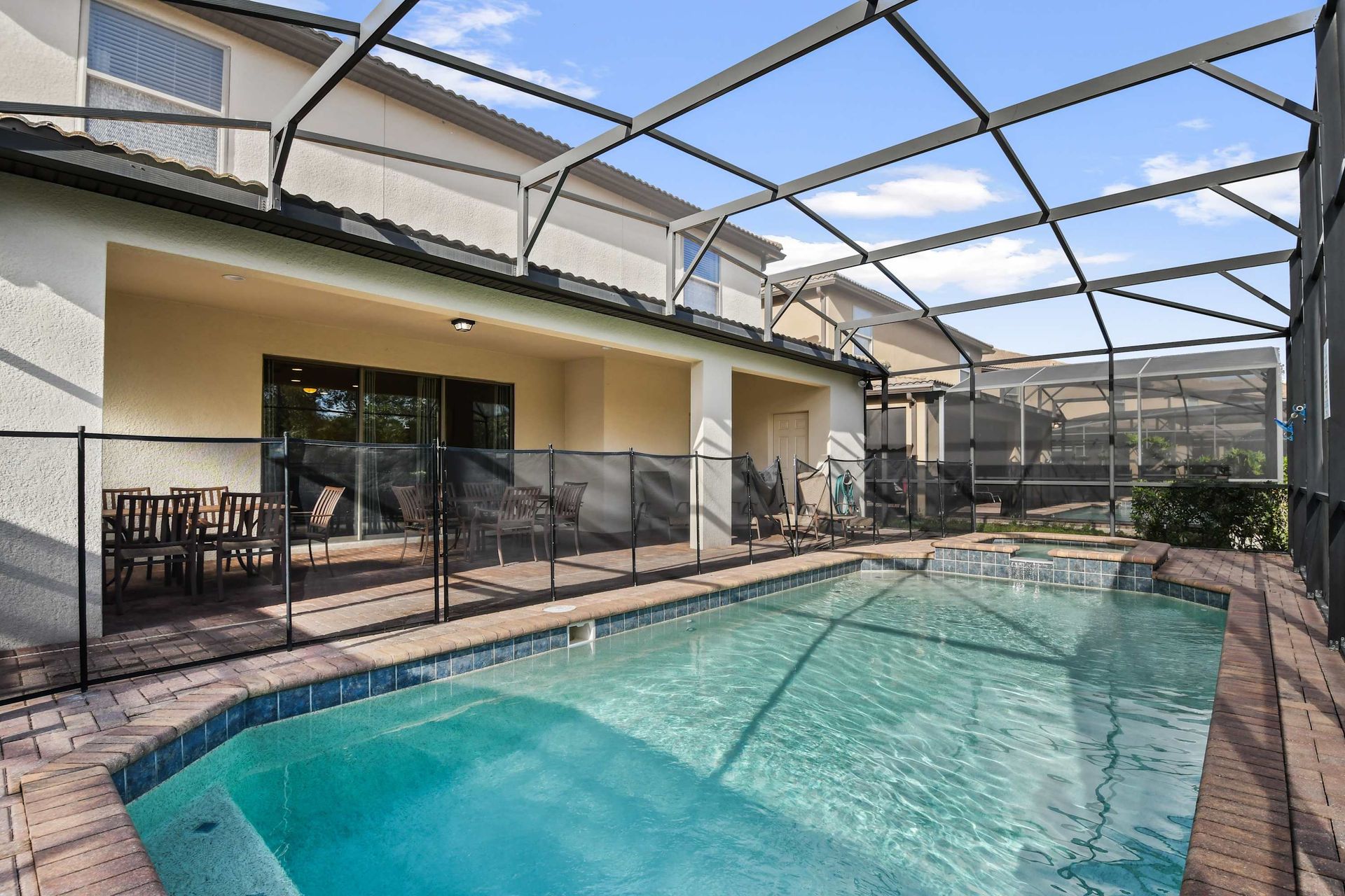 Screened-in pool with spa, peaceful views, and lush greenery for privacy.