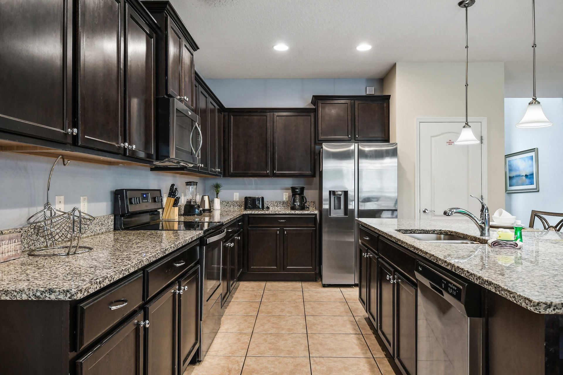 Gourmet kitchen with dark cabinets, granite counters, and stainless appliances.