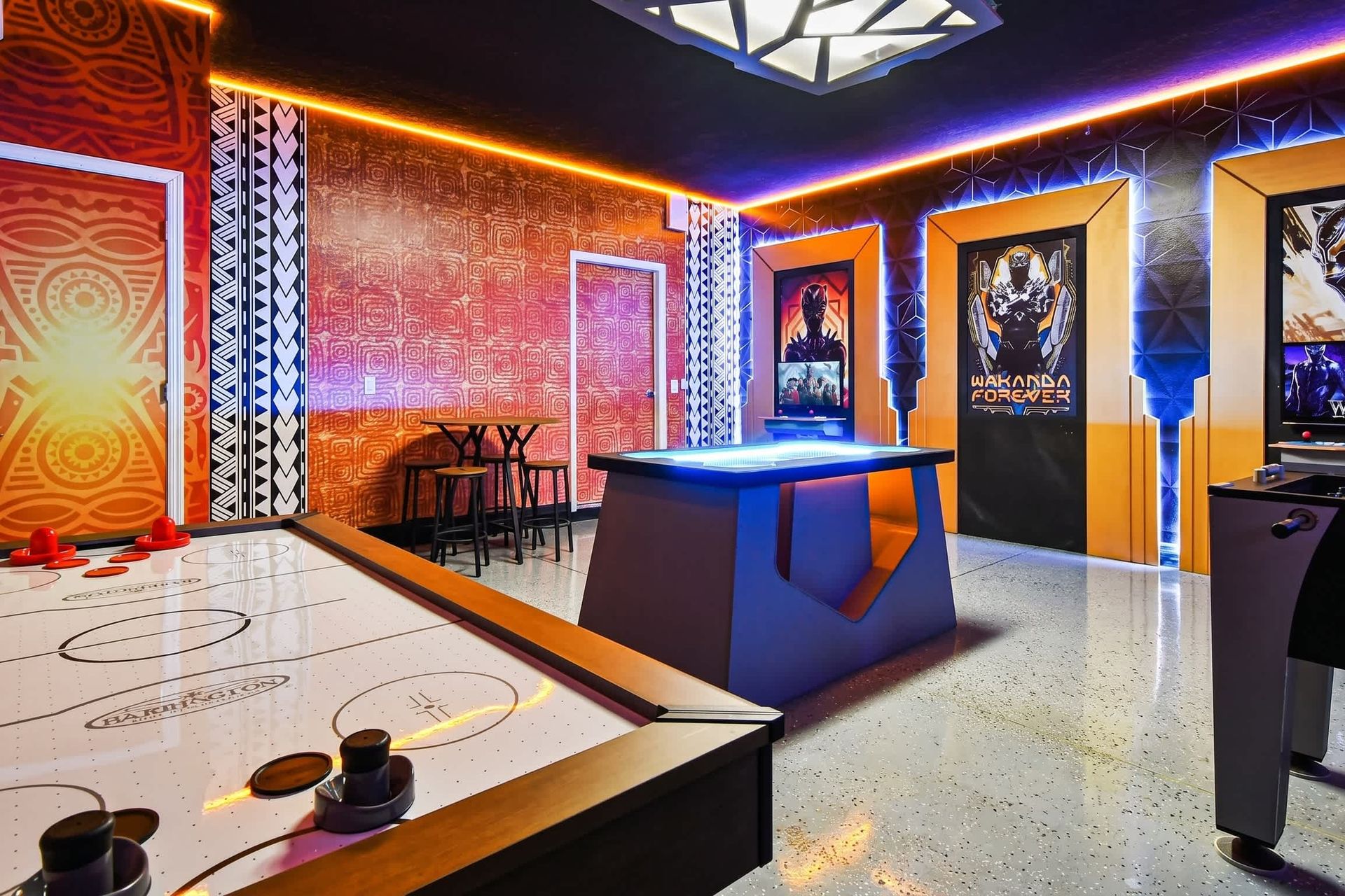 Wakanda-themed game room with air hockey, arcade, and custom lighting design.