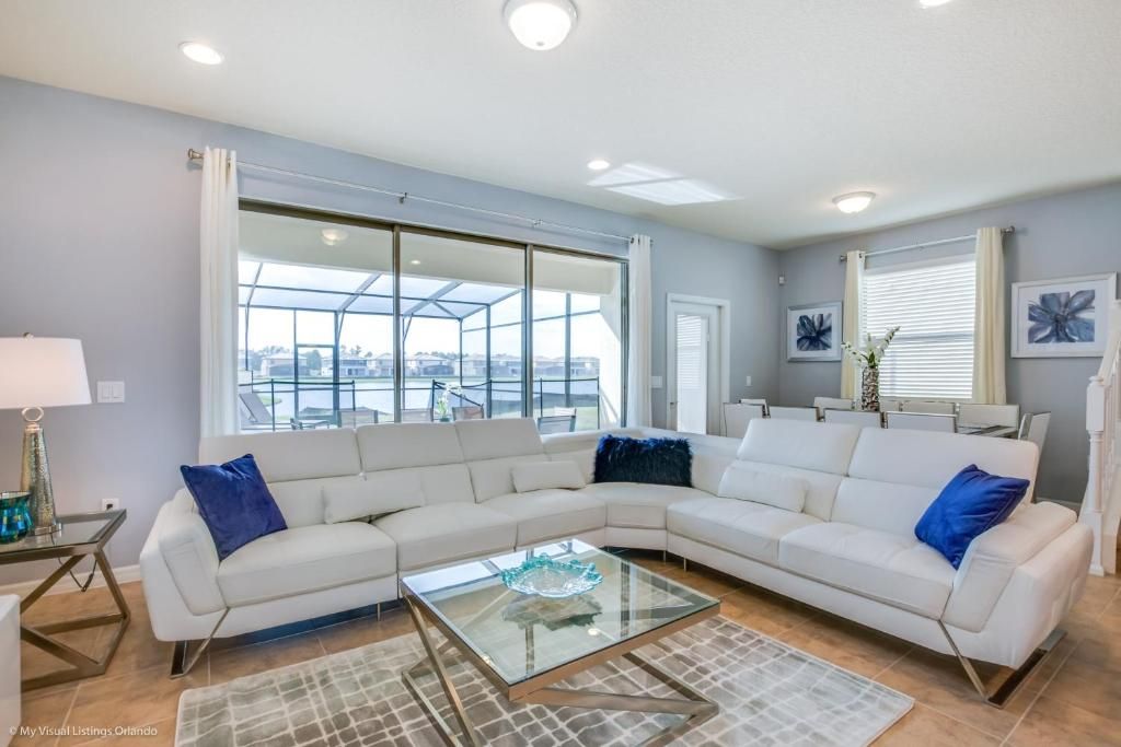 Bright living space with lake views, plush sectional, and elegant dining area.