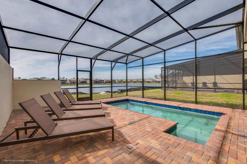 Screened private pool with lake view, sun loungers, and relaxing outdoor space.