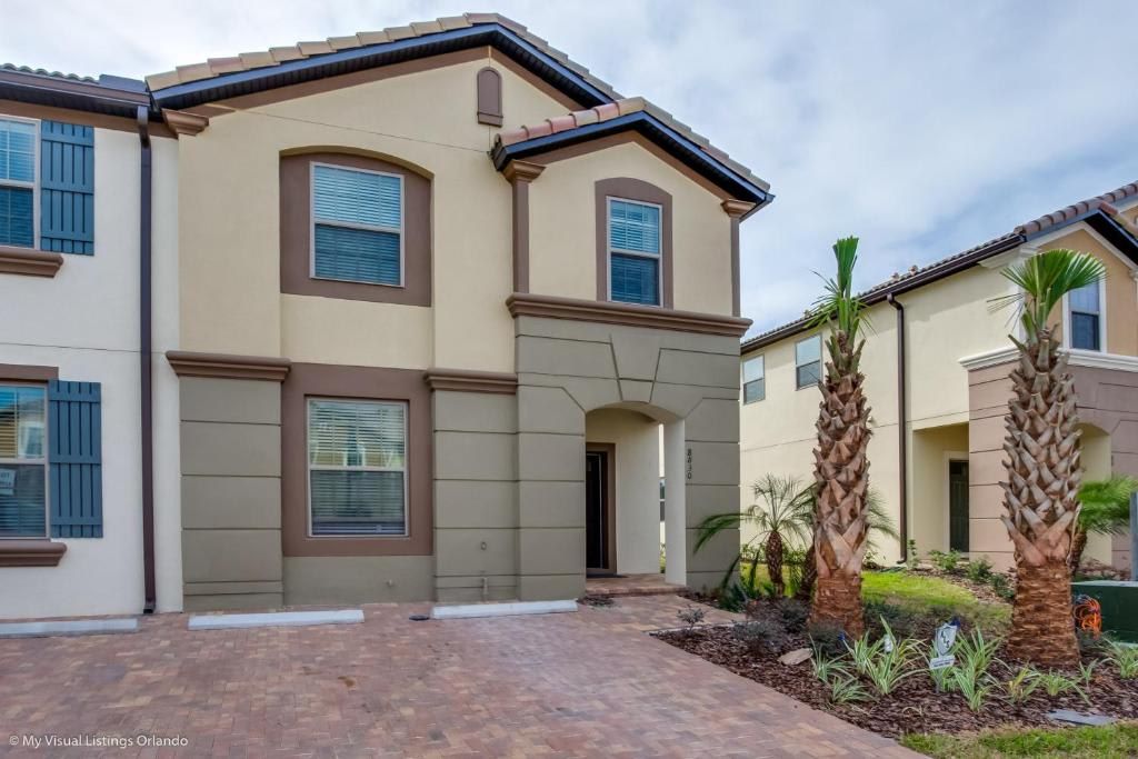 Modern villa with tropical landscaping, private driveway, and elegant exterior design.