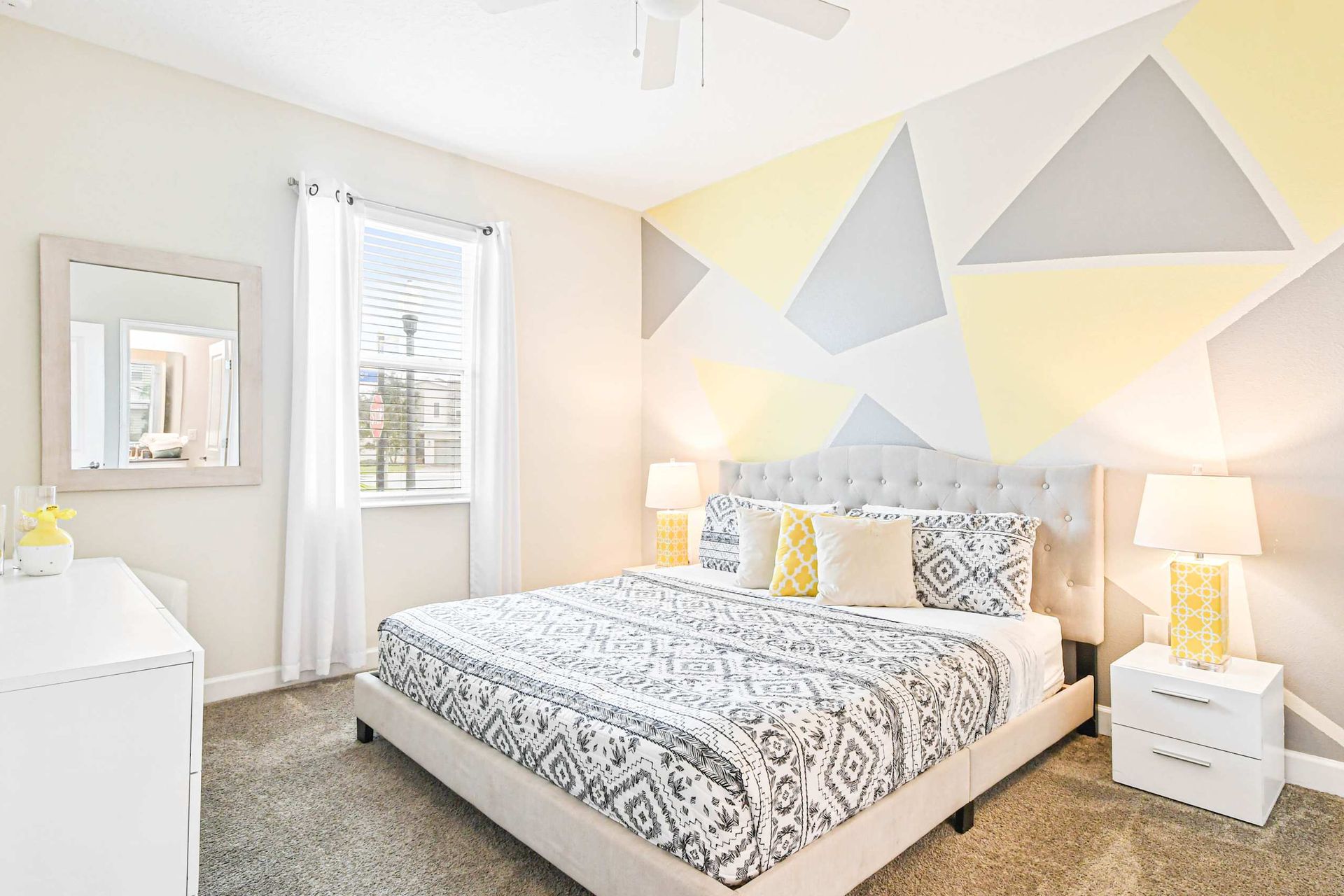 Bright and modern bedroom with geometric accent wall and cozy decor for a stylish retreat.