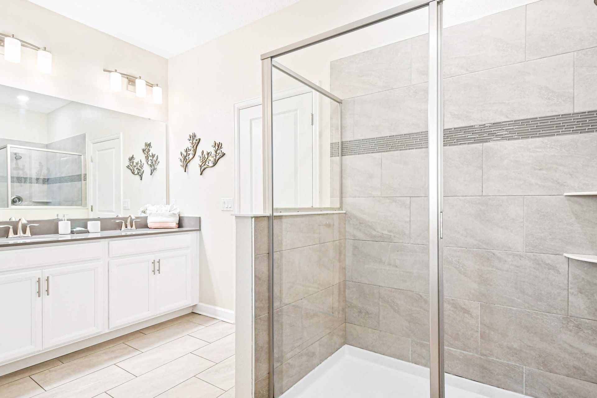 Spacious and stylish bathroom with double sinks, a large shower, and modern lighting!