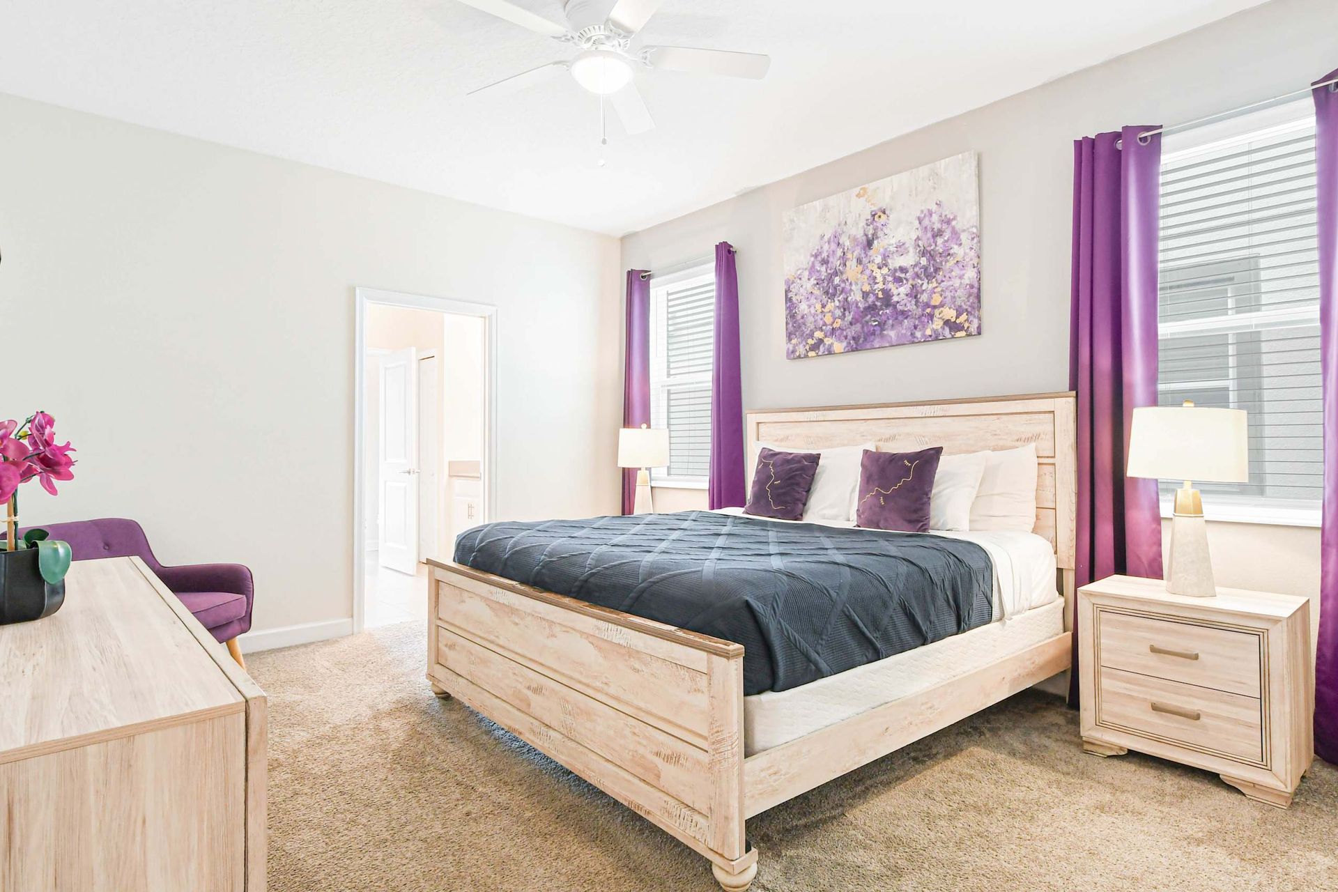 Stylish bedroom with purple accents, cozy bedding, and modern decor for a chic and comfortable stay.