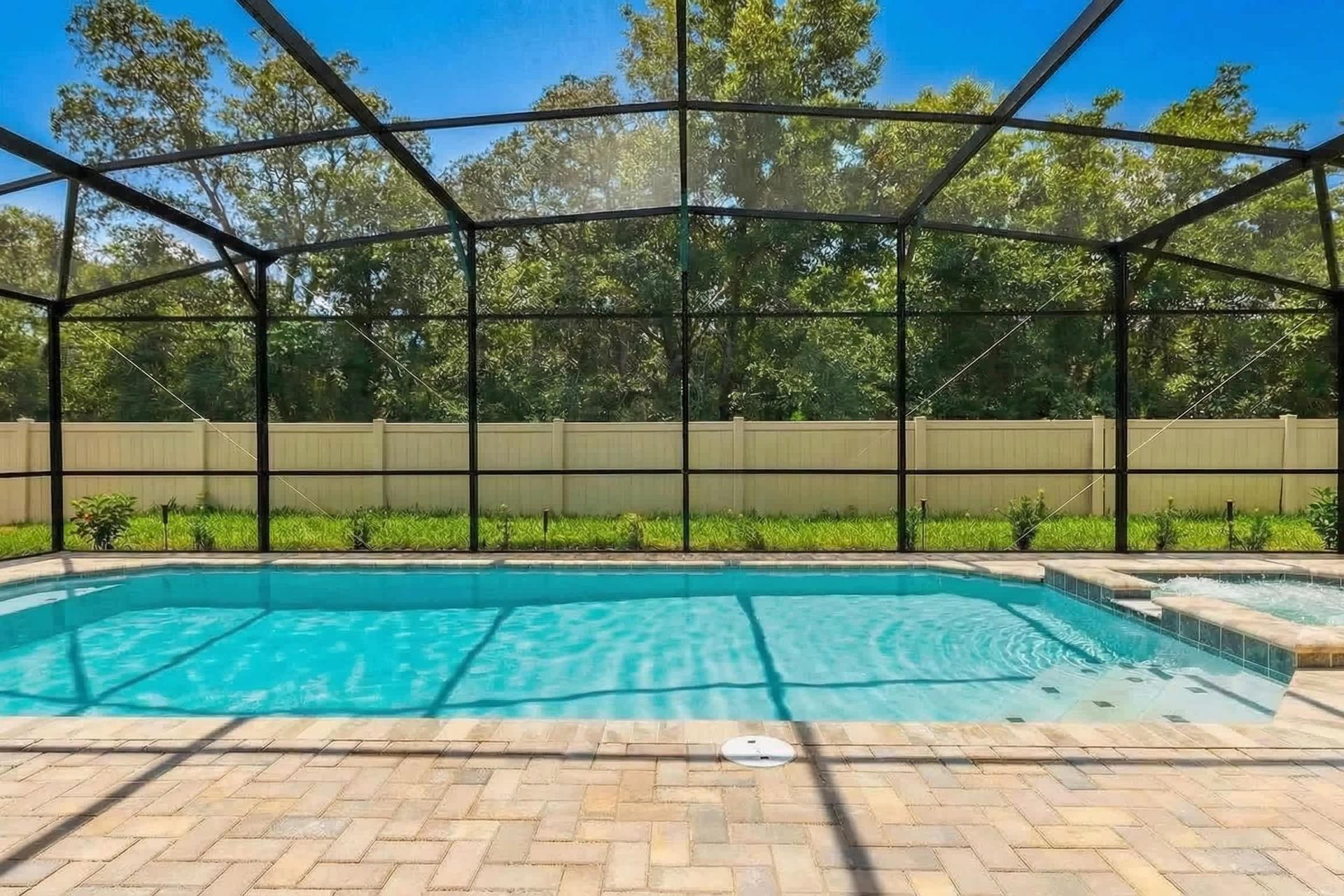 Screened-in pool and spa with serene forest views—pure relaxation!