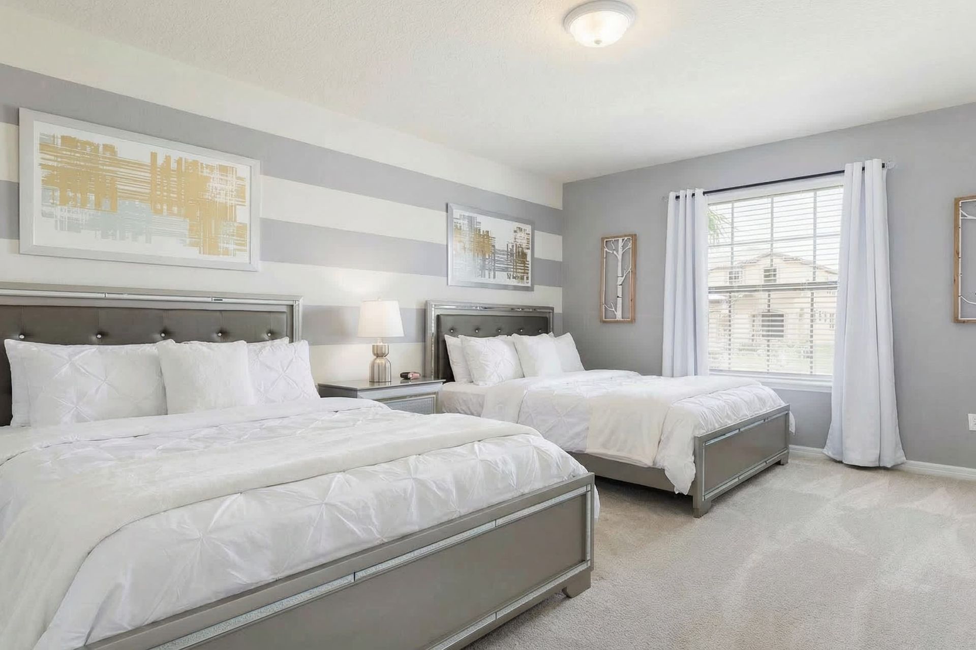 Bright and modern bedroom with double beds, striped walls, and chic decor!