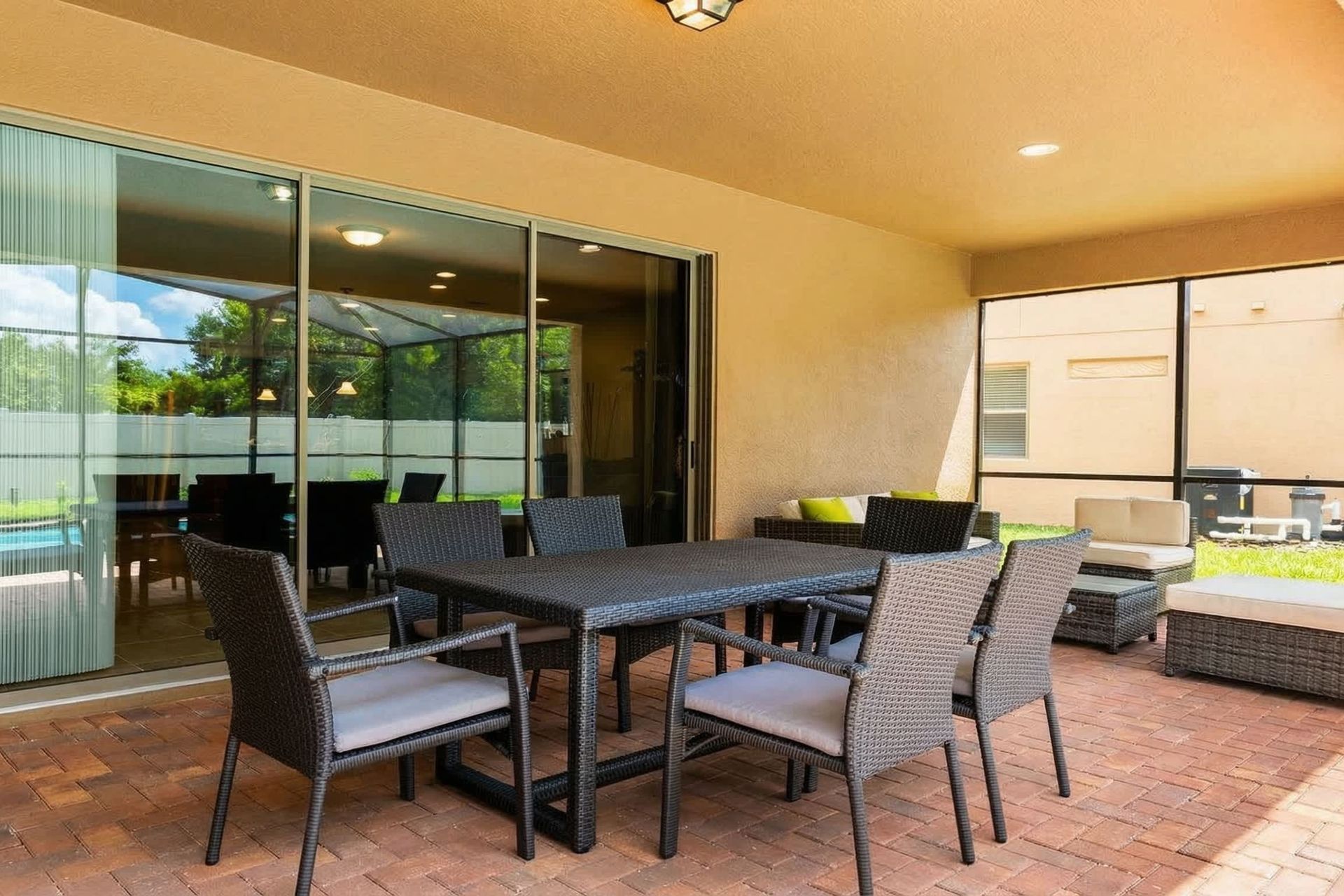 Spacious screened patio with dining table, lounge seating, and outdoor charm!