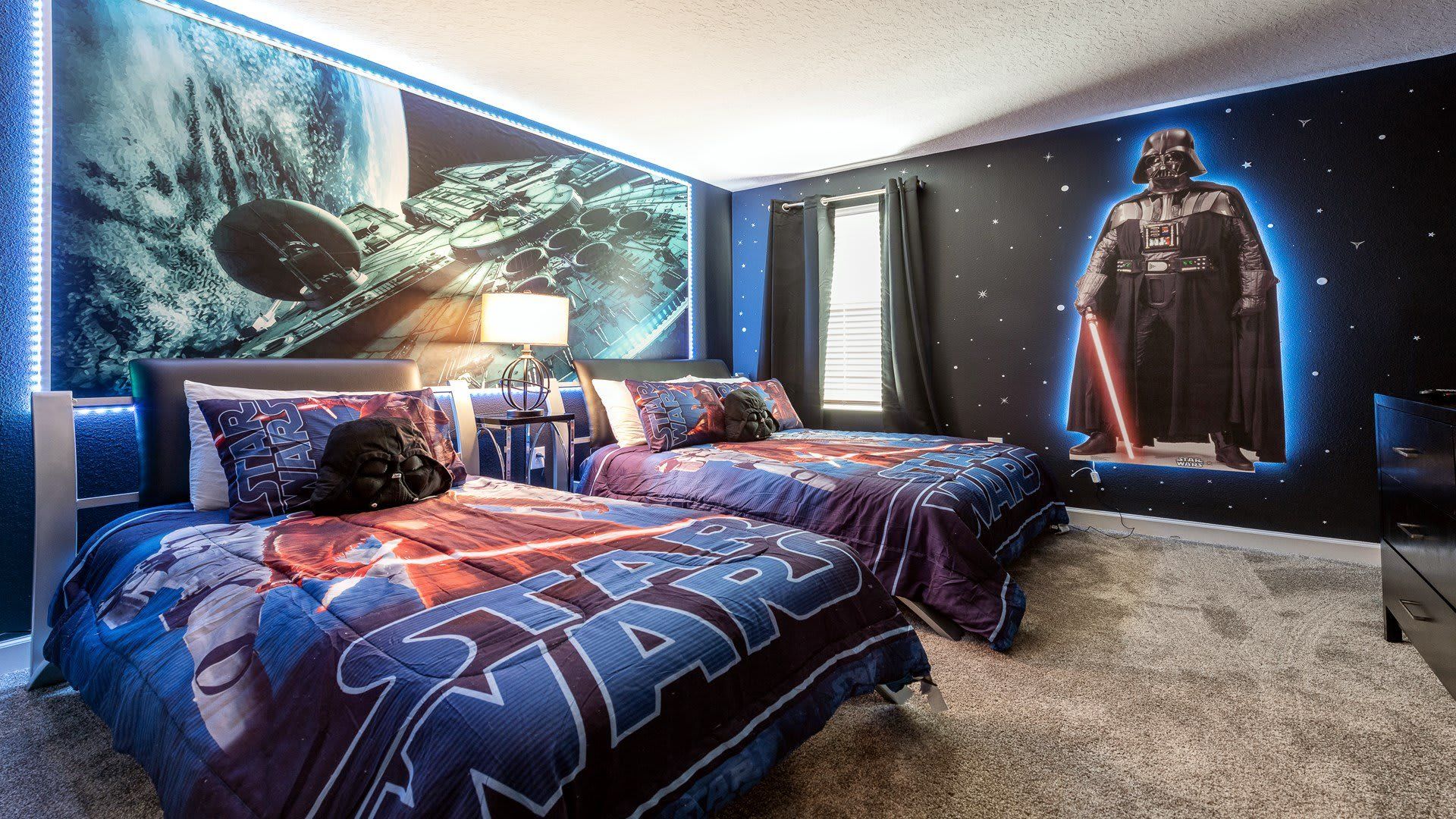Galactic-themed bedroom with twin beds, Star Wars decor, and glowing murals