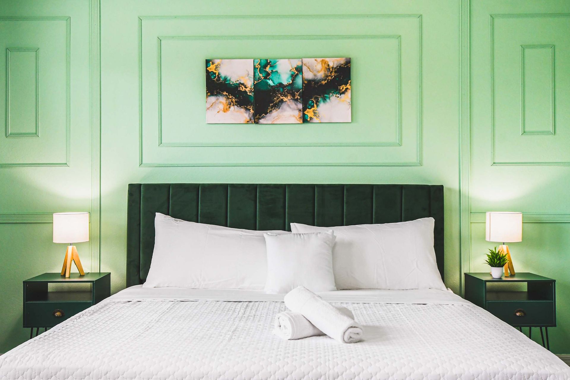 Elegant king suite with calming green tones, plush bedding, and modern accents.
