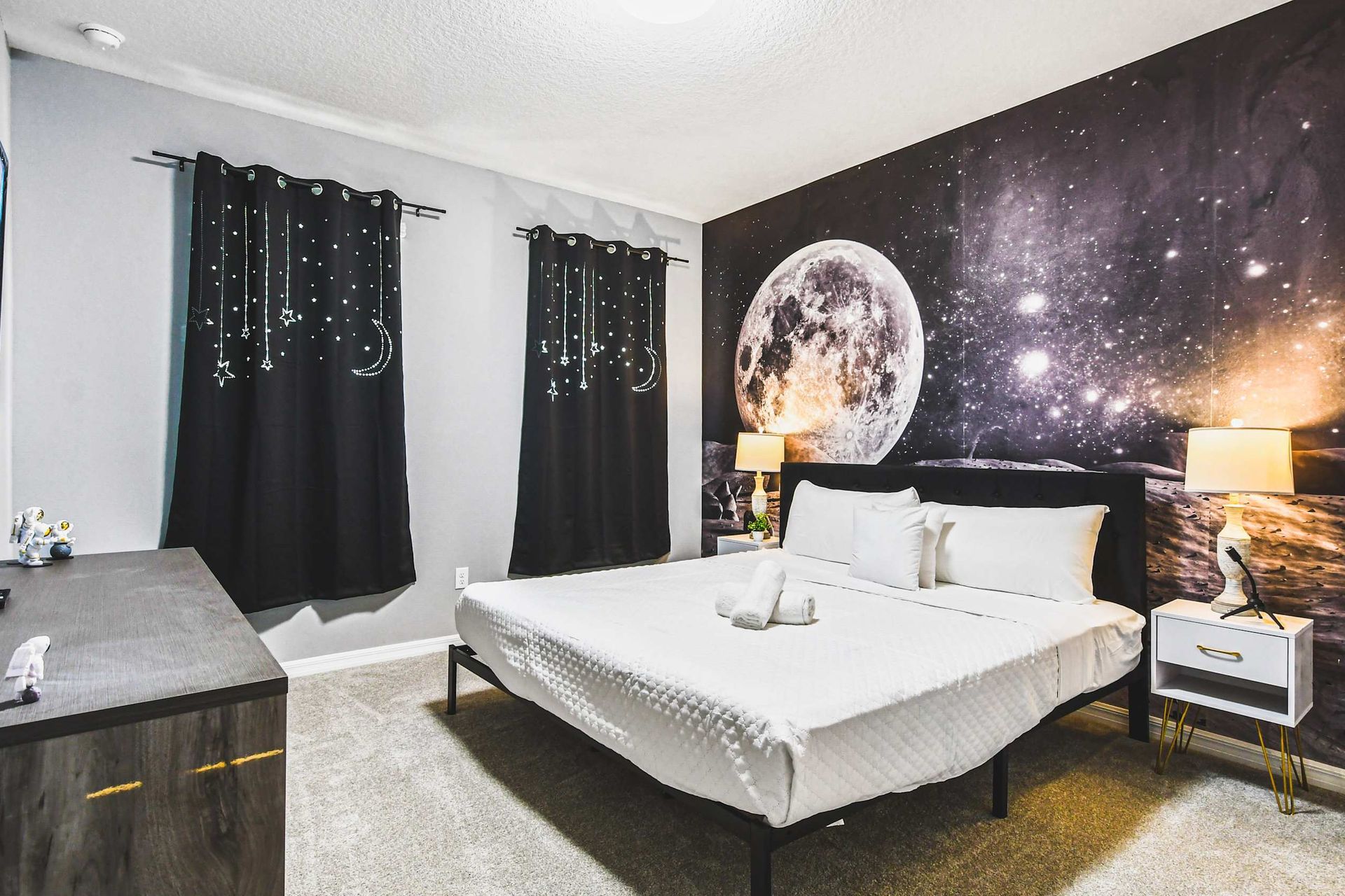 Space-themed bedroom with moonlight ceiling, starry decor, and cozy cosmic charm.