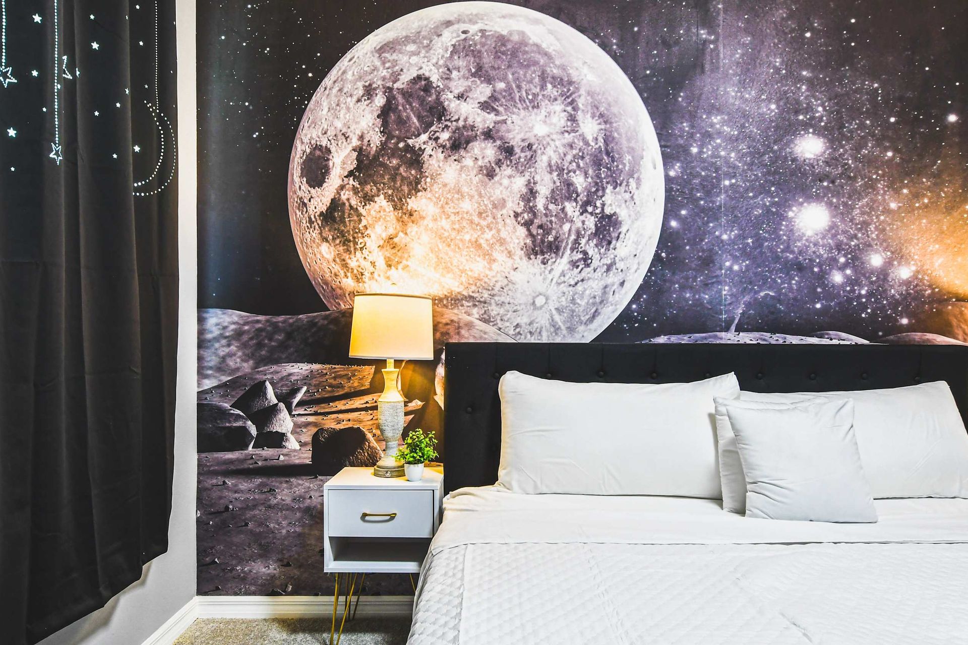 Dreamy space-themed room with moon mural, cozy bed, and glowing night vibes.